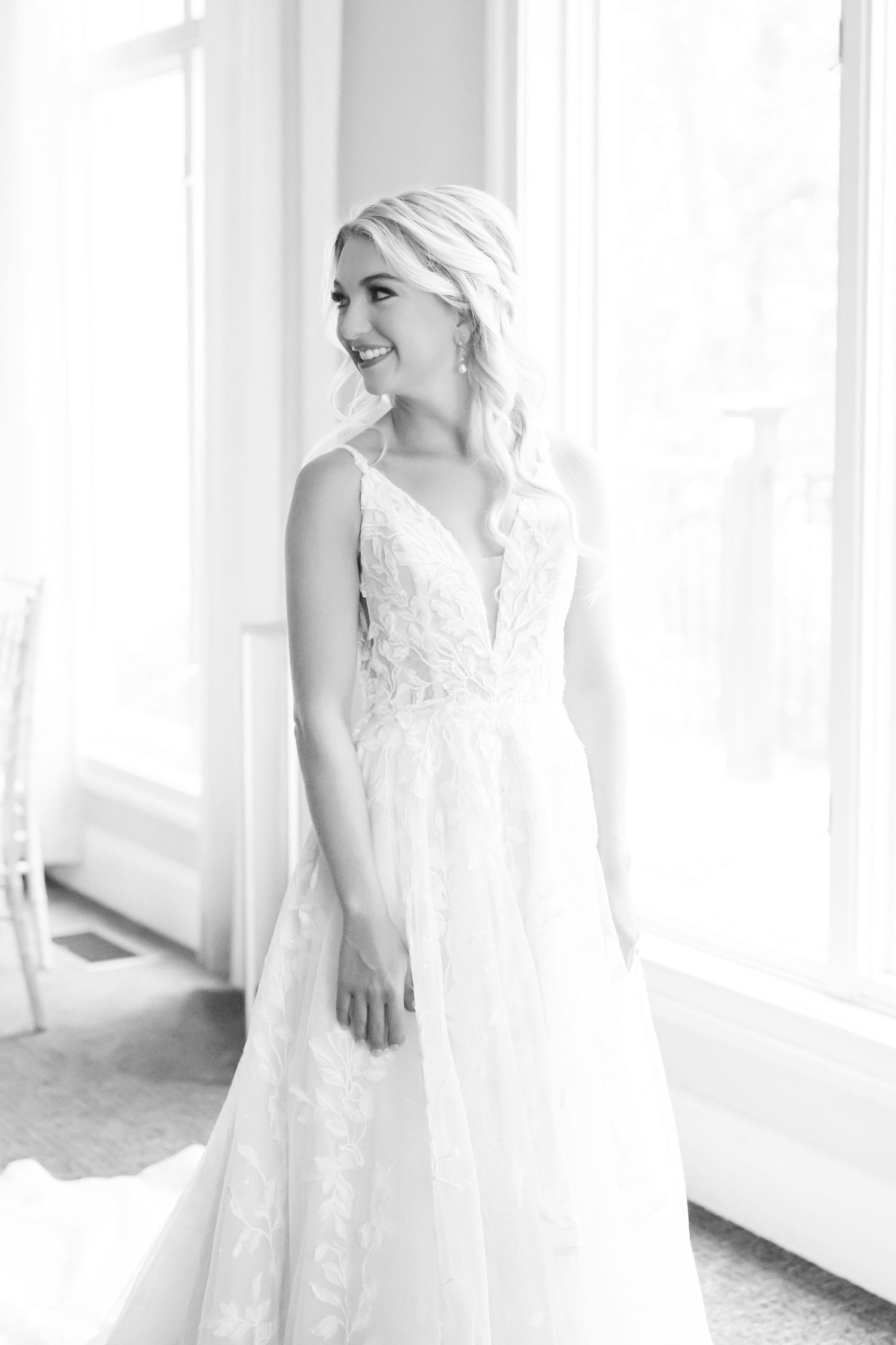 Elegant white lace wedding dress details captured in bright natural window light.