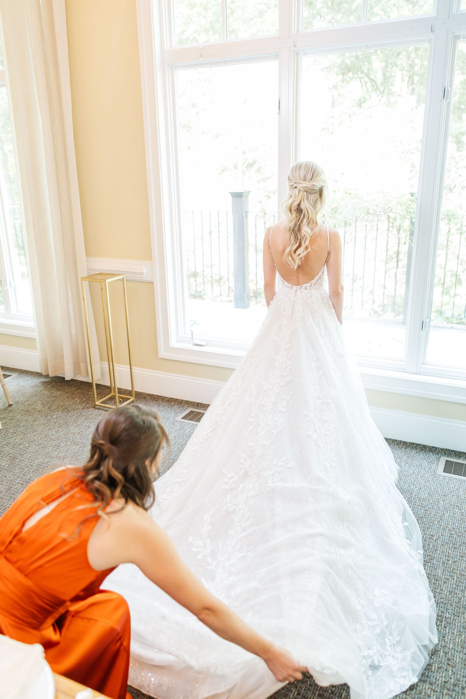 Series of photos showing bridesmaid in orange dress helping with wedding dress train.