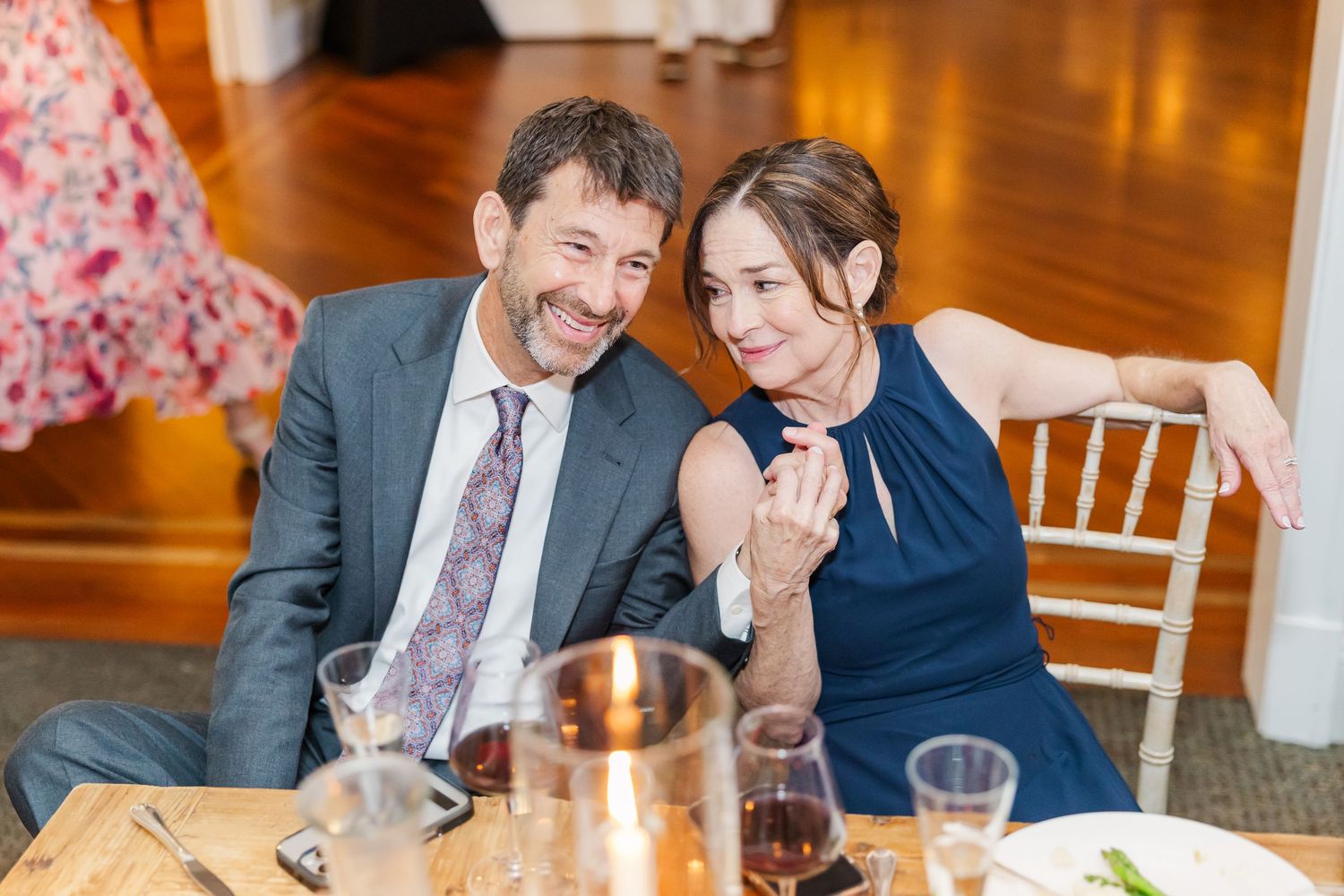 Wedding reception guests seated at decorated tables enjoying dinner and conversation.