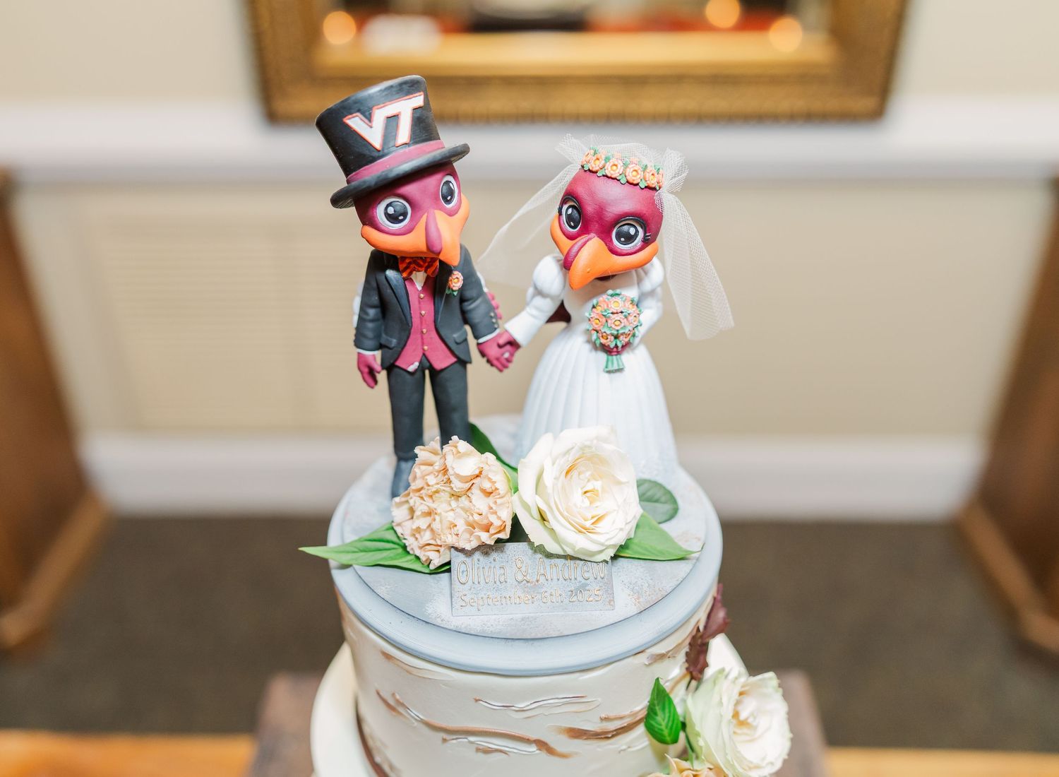 Wedding cake decorated with colorful owl cake toppers and delicate floral accents on a light blue base.