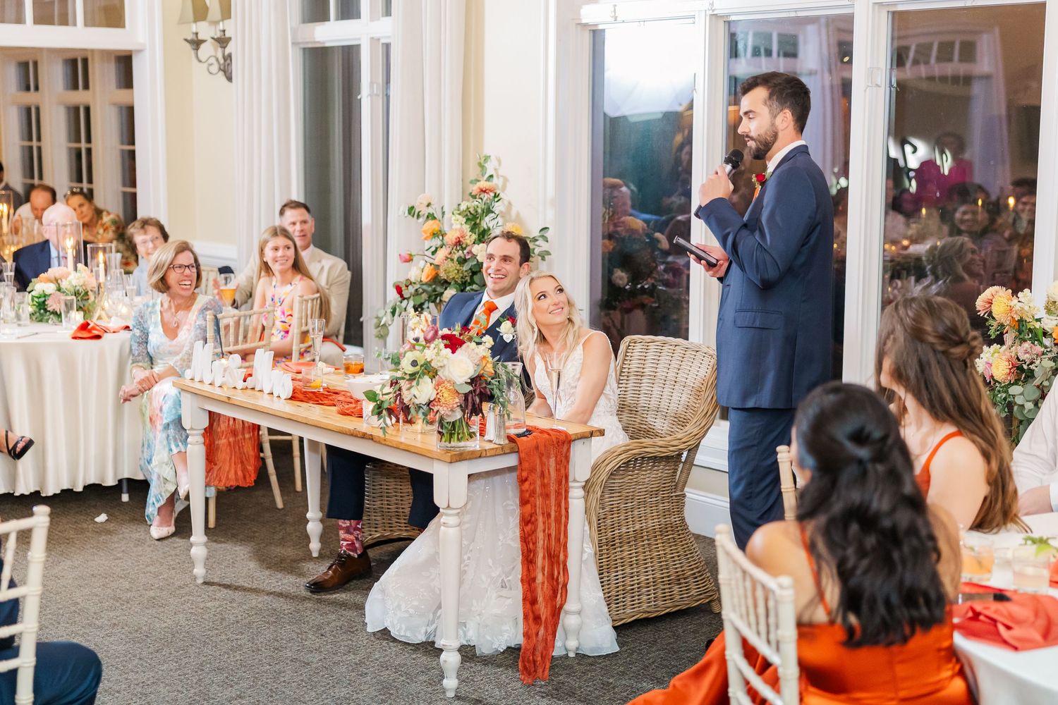 Wedding reception venue decorated with floral centerpieces and white tablecloths.