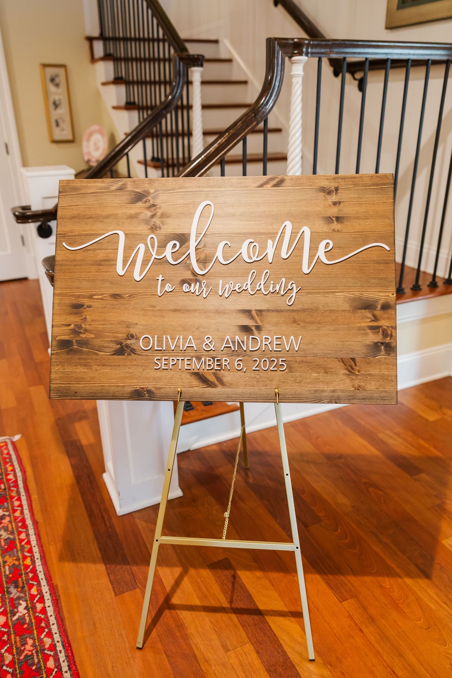 Rustic wooden welcome sign for a September wedding displayed on an easel.