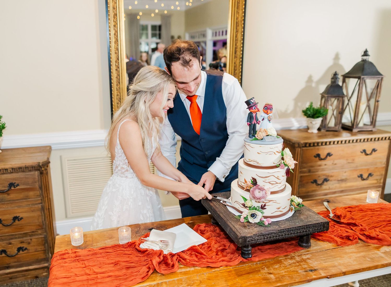 Wedding couple cuts their multi-tiered cake together at the reception.