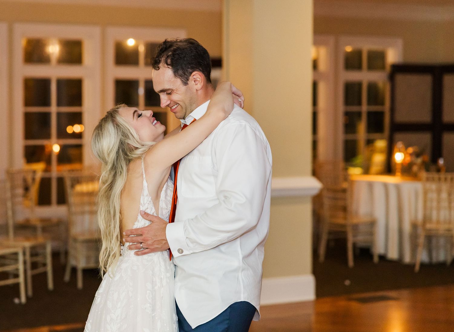 Couples dancing together during a romantic moment at an elegant indoor wedding reception.