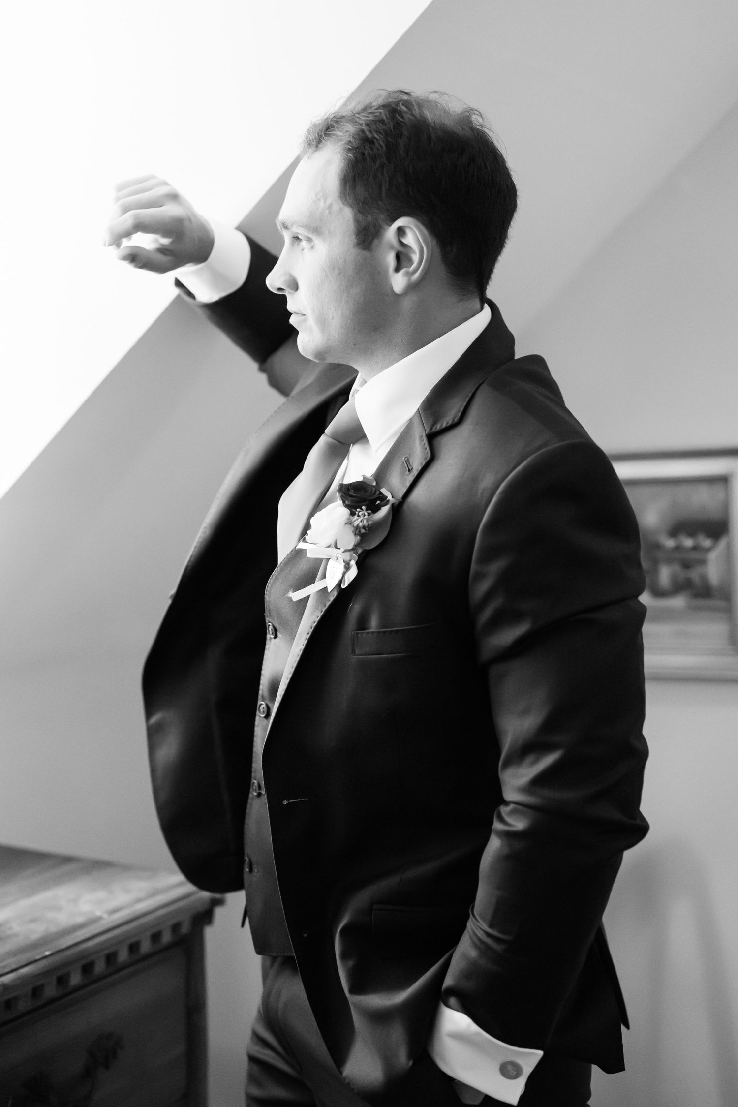Four black and white photos show a person in a suit jacket looking in different directions against a light background.