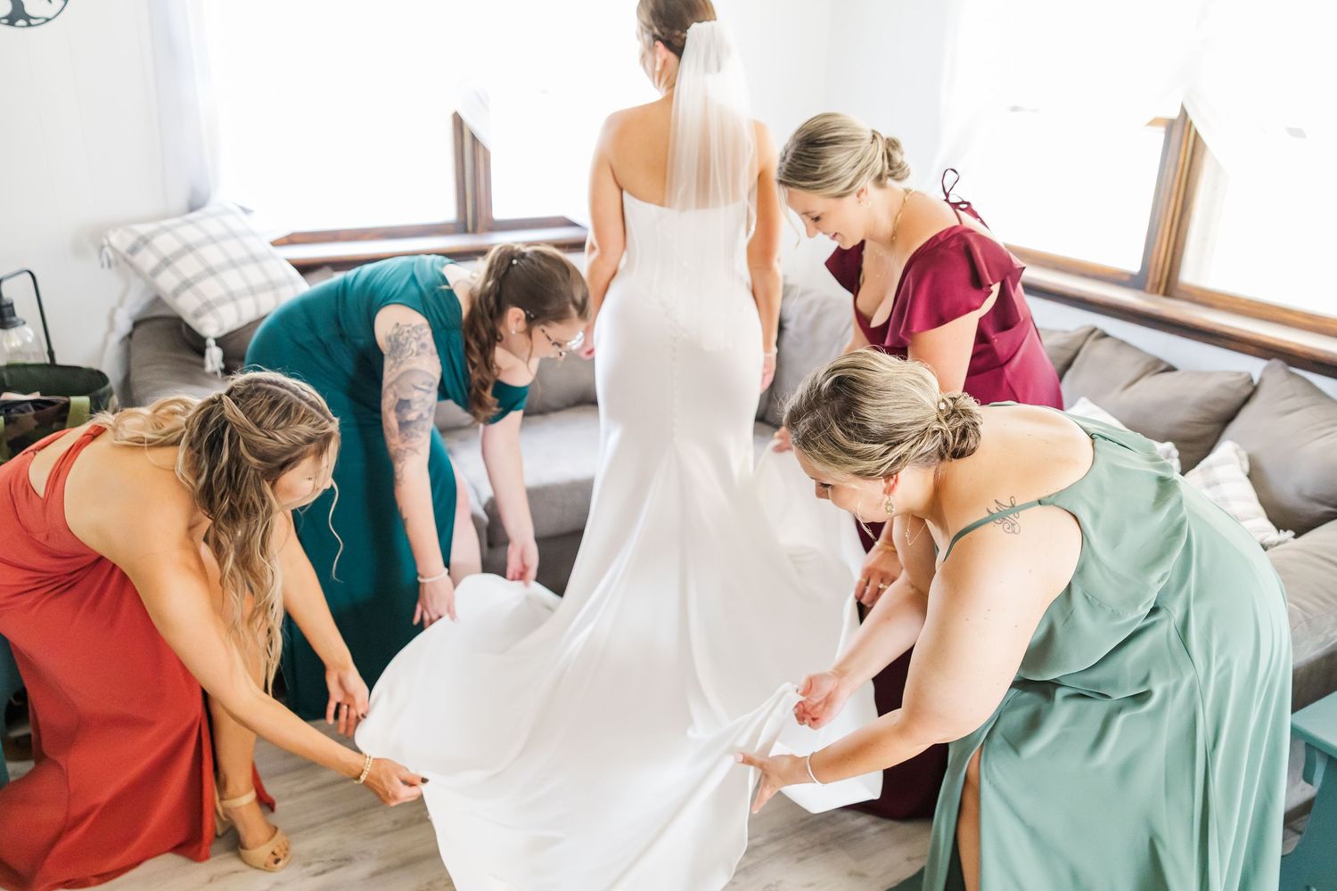 A group of people gather around a large white paper on a table to collaborate and write together.