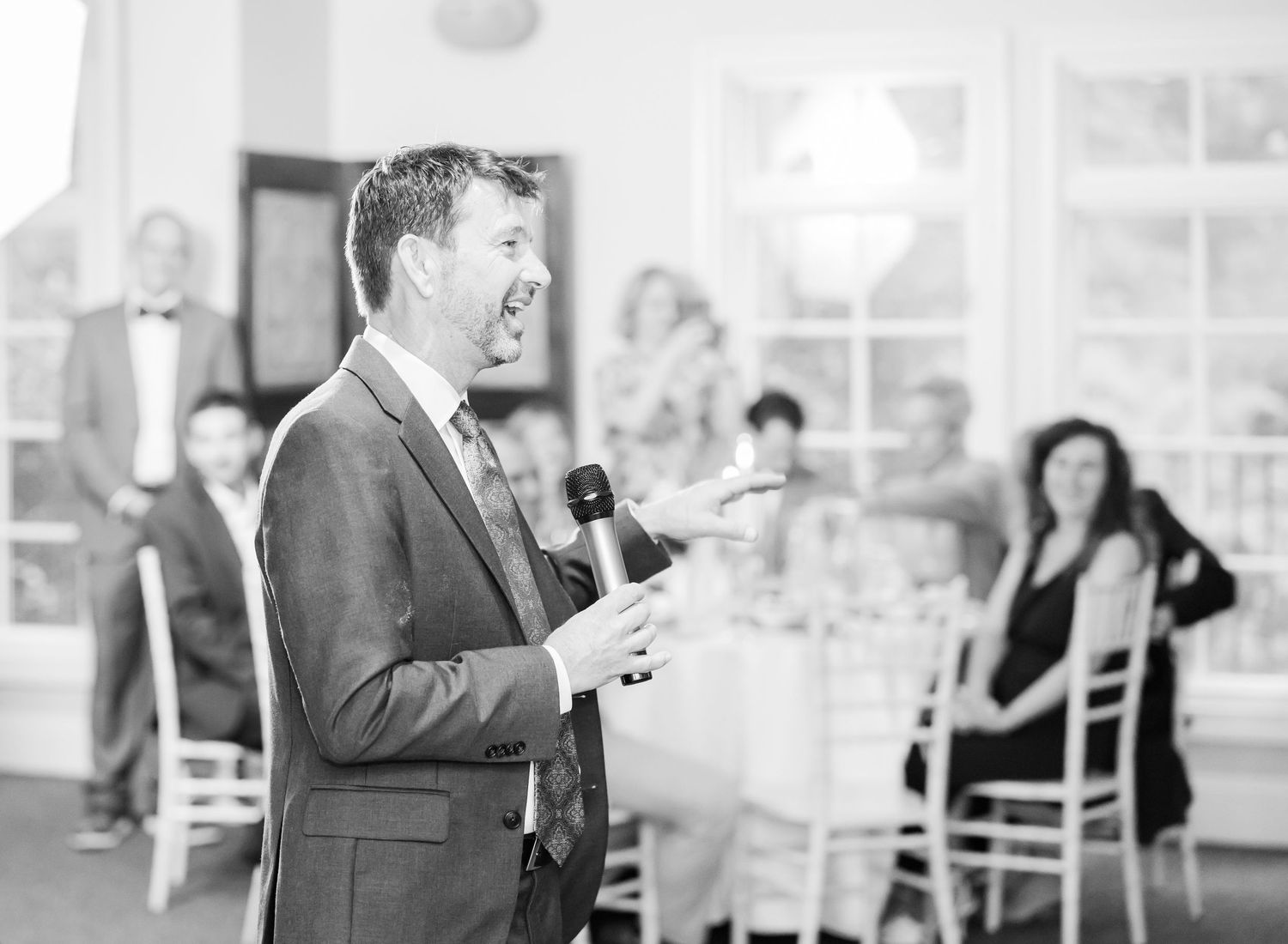 Black and white wedding reception scene with guests dancing and celebrating.