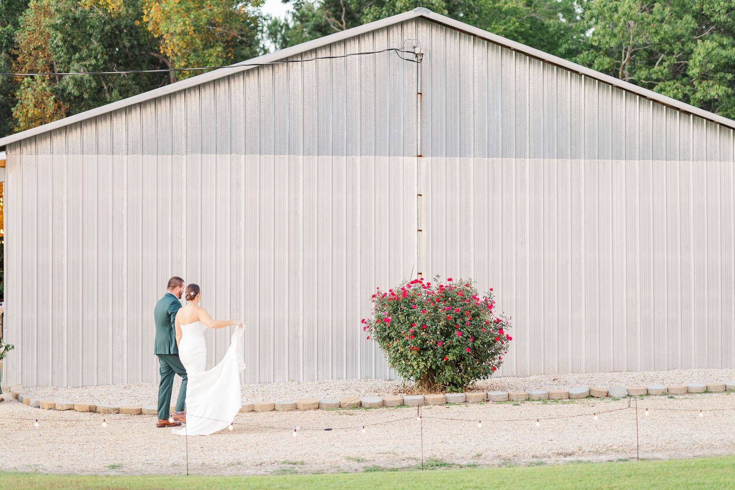 A series of romantic wedding photos taken against a rustic barn wall with blooming red flowers.