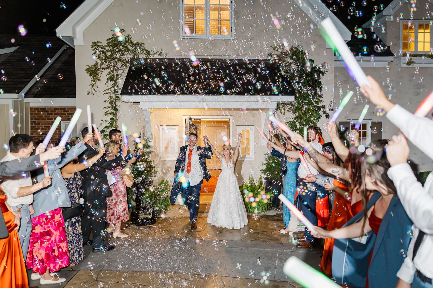 Wedding celebration with confetti falling as guests celebrate outside at night.