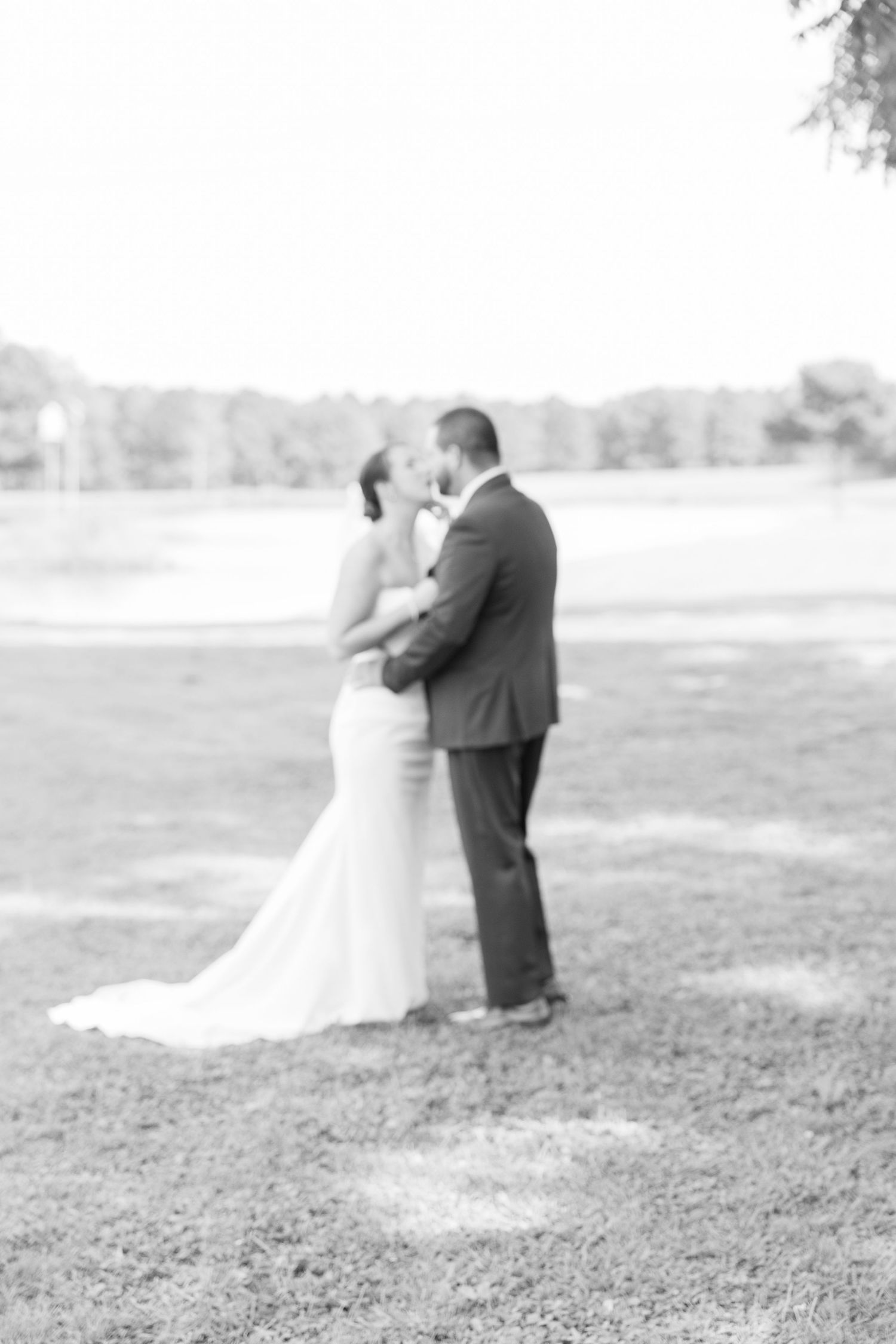 Romantic black and white wedding portraits captured on a misty field.
