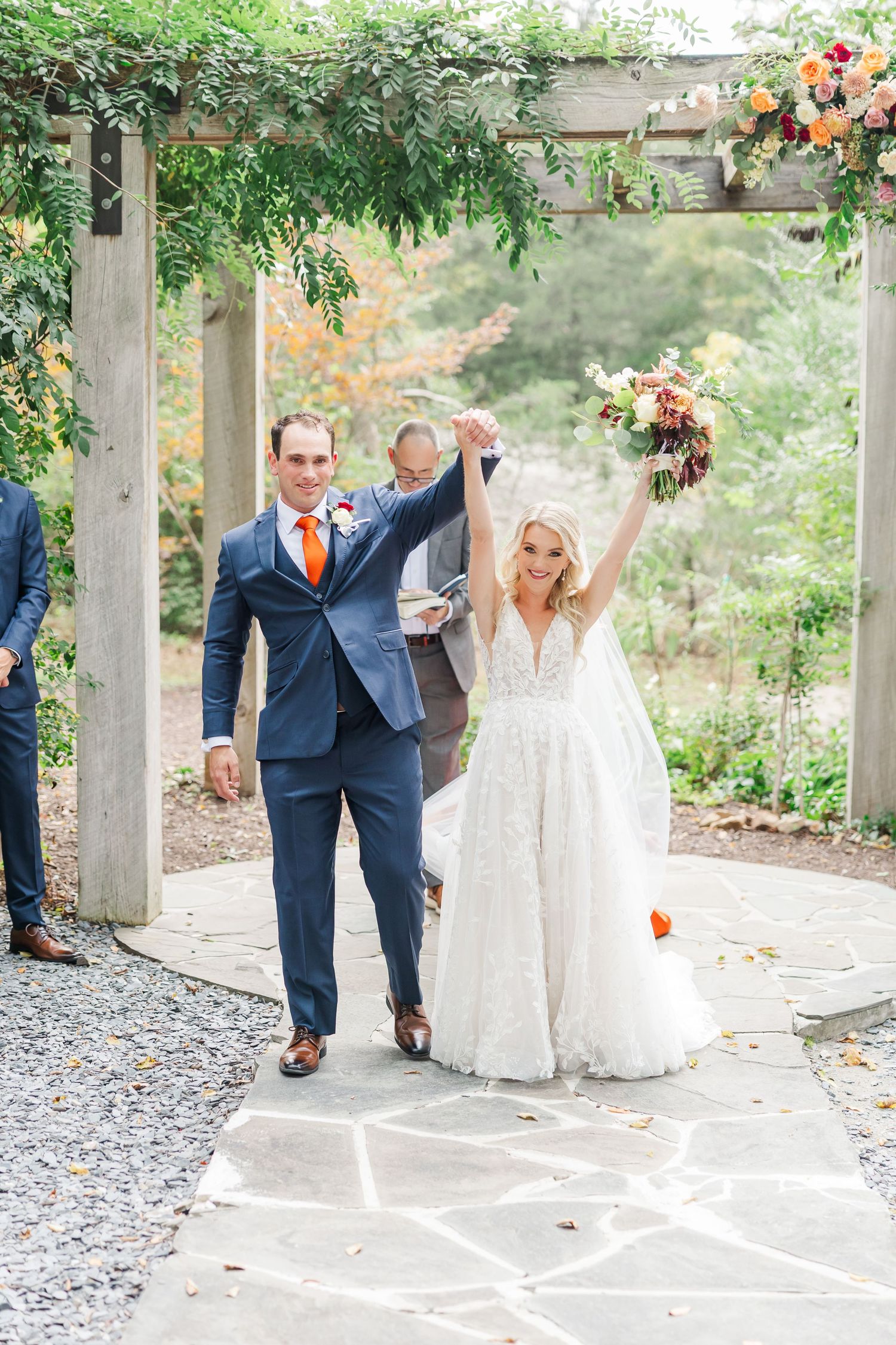 Joyful wedding celebration sequence showing couple walking and jumping on decorative stone pathway in garden setting.