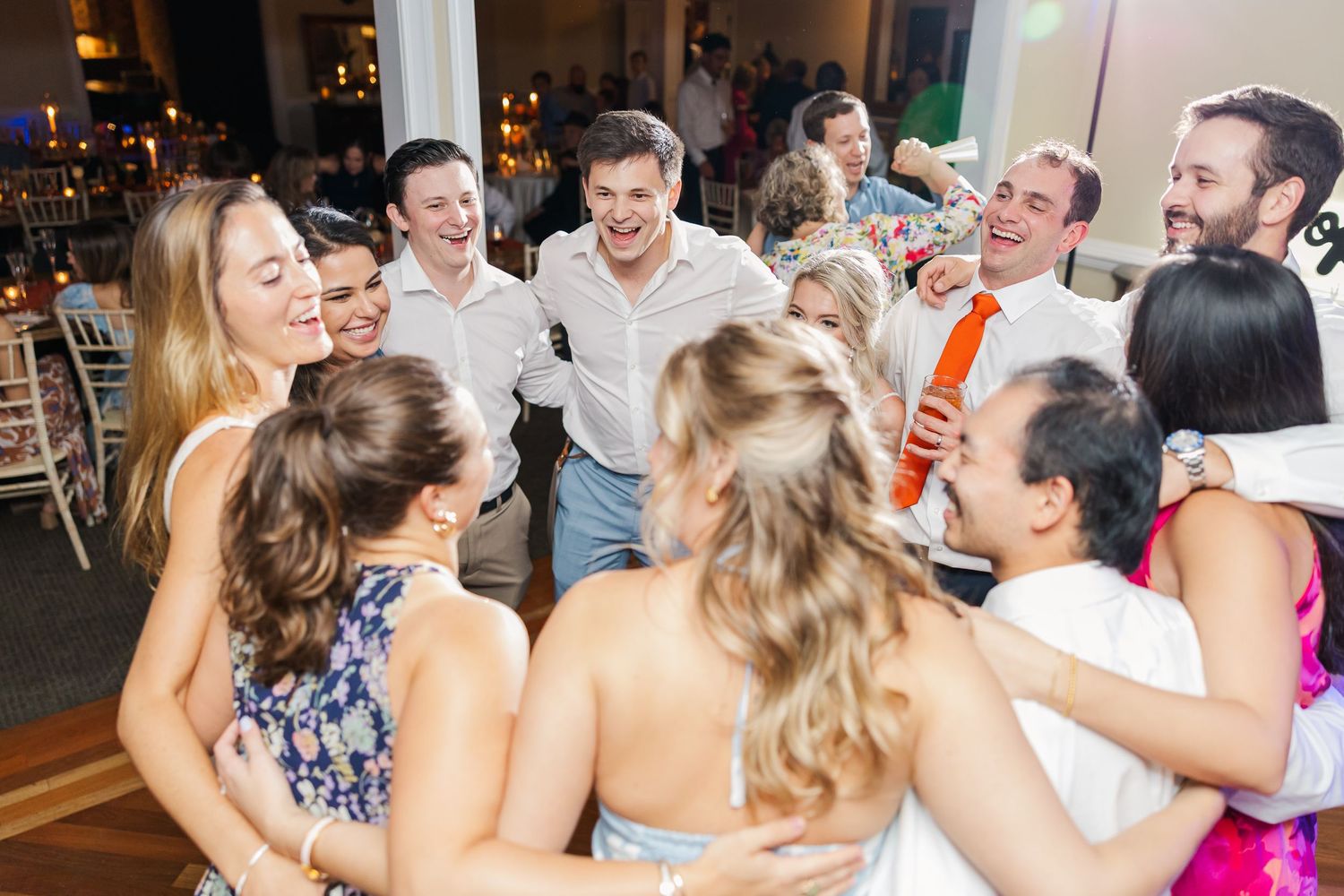 Guests celebrate on the dance floor during an evening wedding reception.