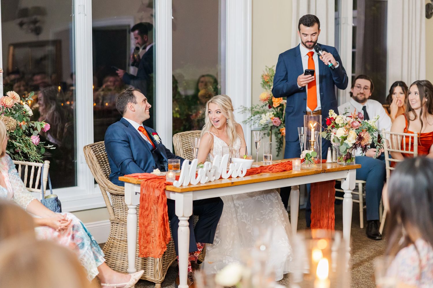 Wedding reception celebration with guests dancing and mingling at decorated tables.