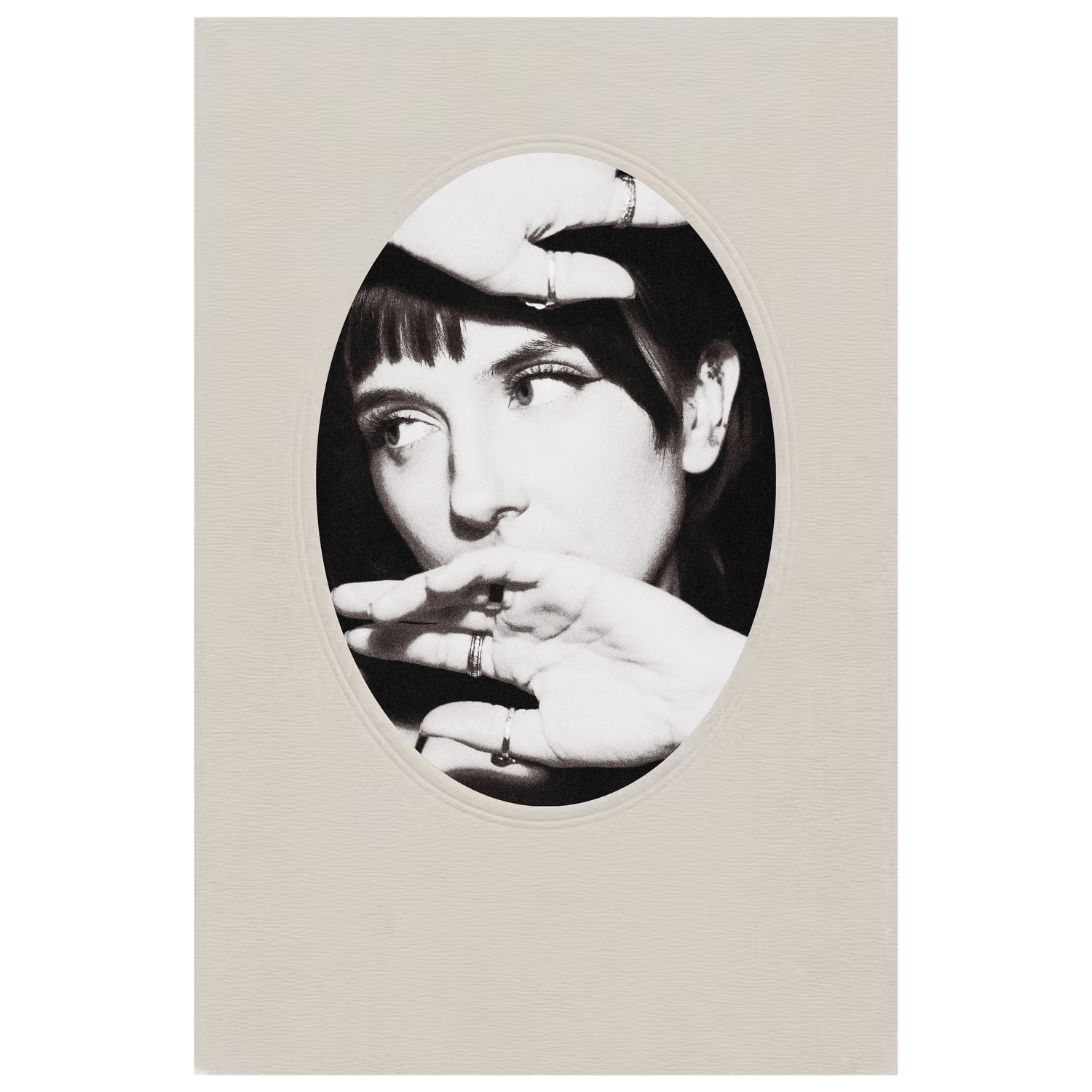 Black and white oval-framed portrait with hands positioned near face.