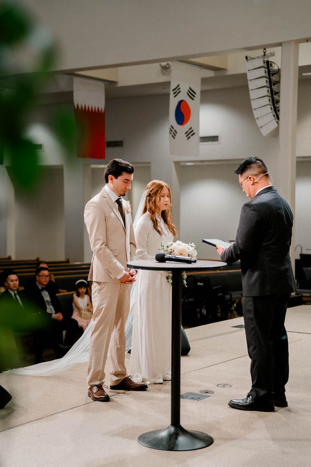 A wedding ceremony shows a couple and officiant at a simple church venue.