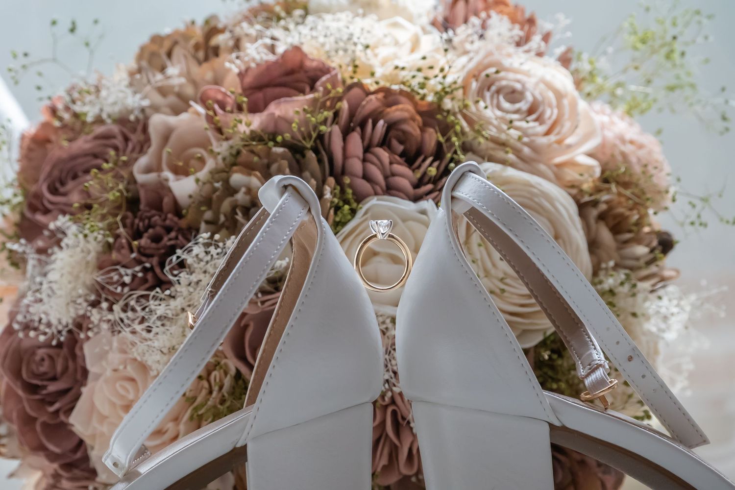 Elegant wedding bouquet with dusty rose and cream colored flowers tied with white satin ribbon. The barn at Wolfe creek, Akron, Ohio