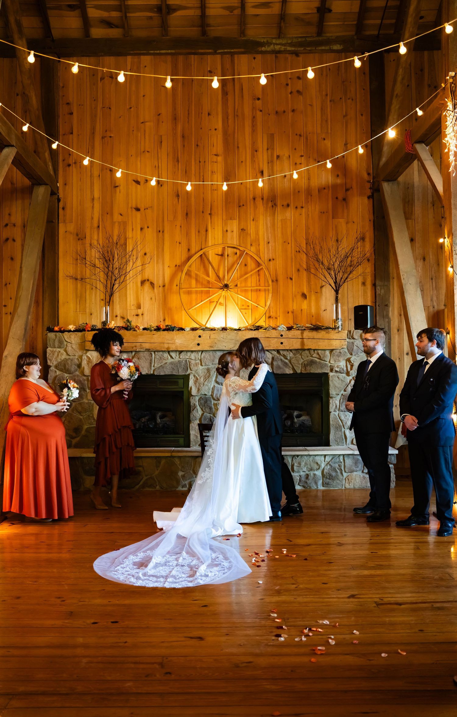 Wedding reception in rustic barn venue with string lights overhead and couples dancing on wooden dance floor. Valley City Ohio