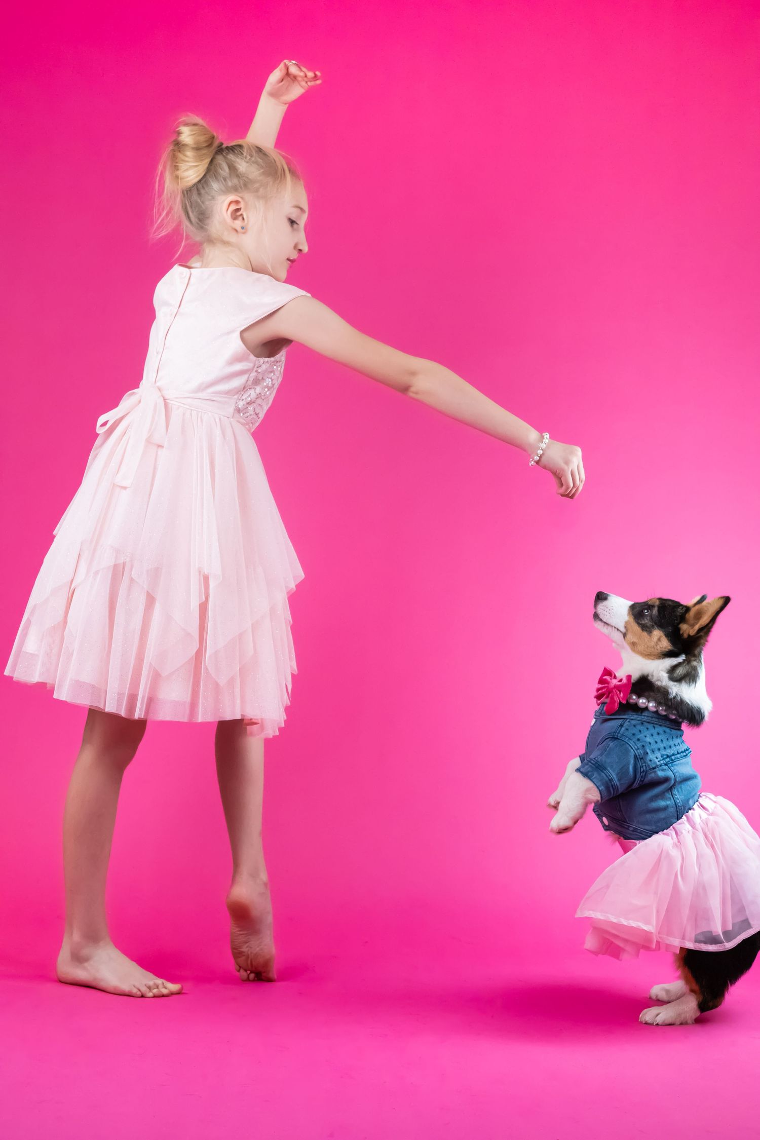 Playful series of poses showing a white dress twirling with a small black and white cat against a vibrant pink background.