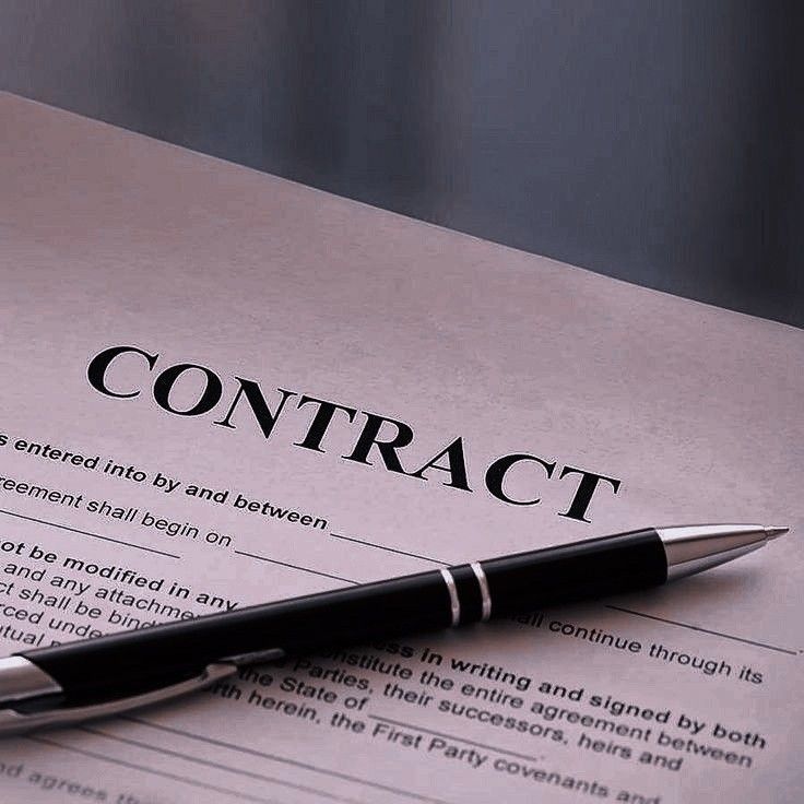 Contract document with pen positioned for signing.