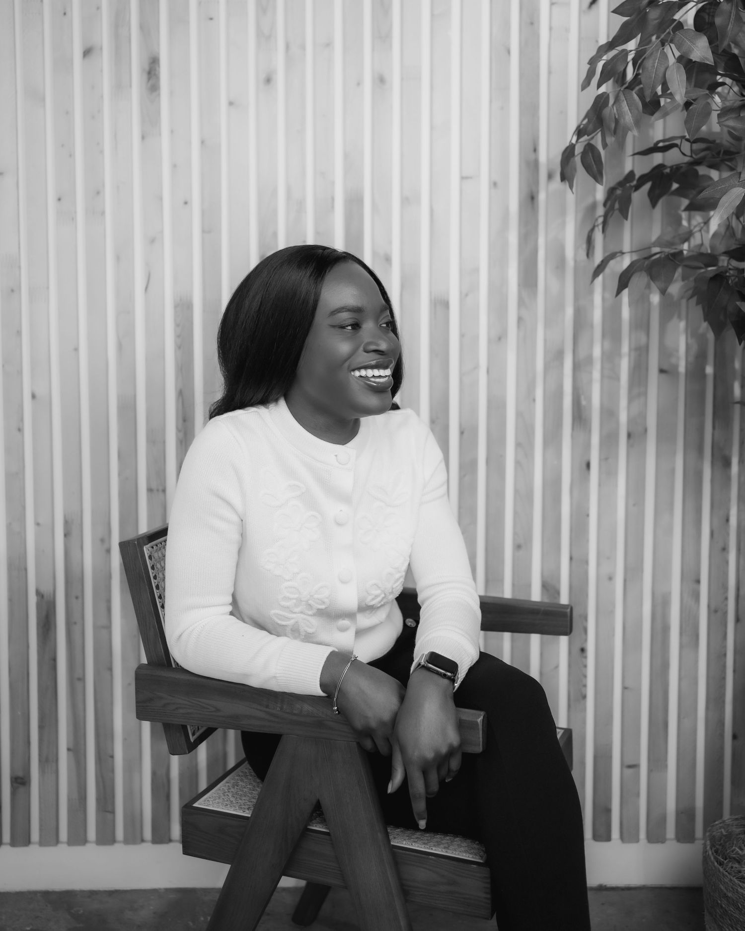 Black and white photo series capturing candid laughter and joy against a striped wall backdrop.