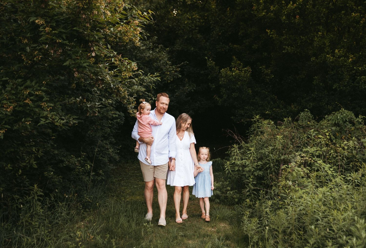 A series of candid outdoor family photographs taken in a lush green forest setting during golden hour.