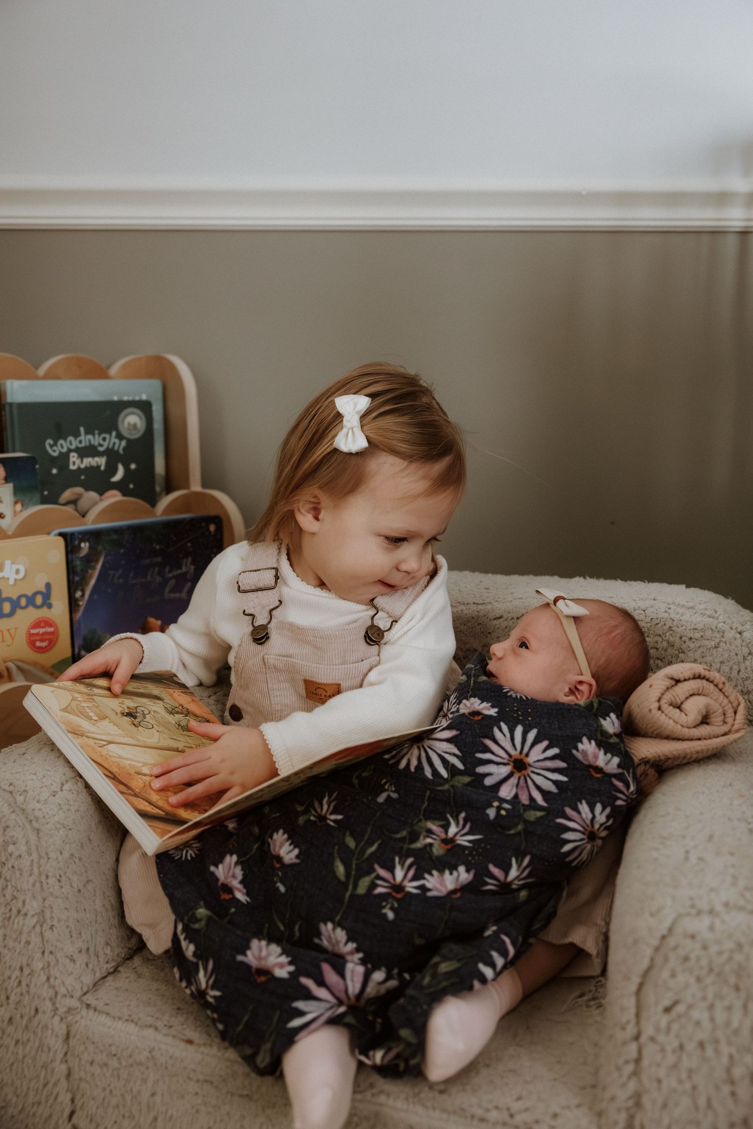 Children relaxing on a comfortable couch while looking at a book together.