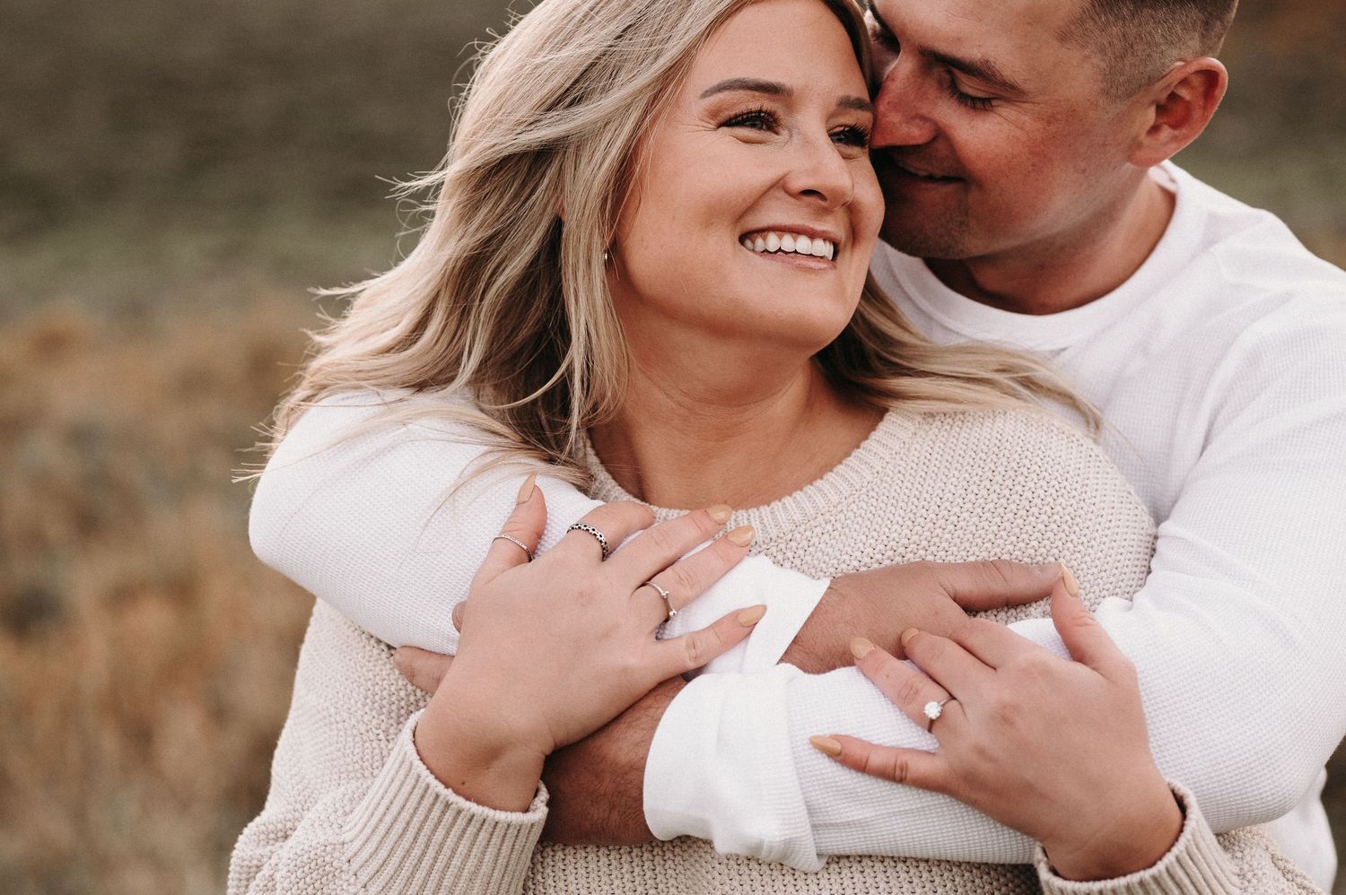 Intimate moment between couple in warm sweaters during fall photo session.