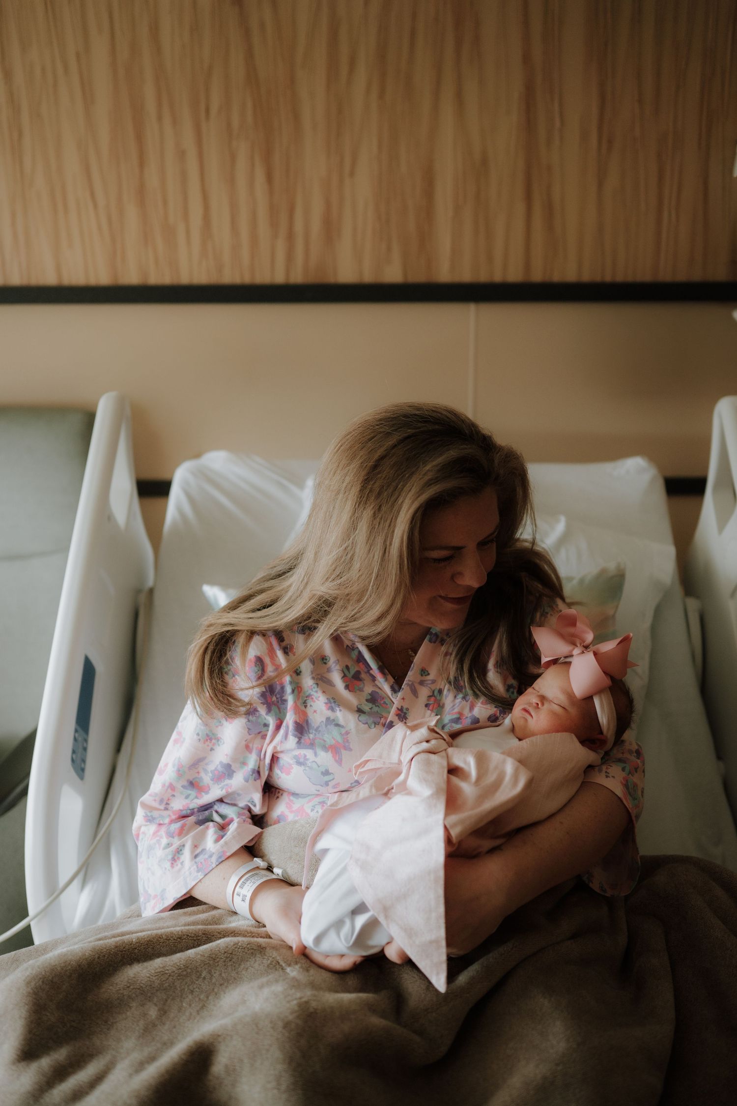 A tender moment in a hospital room with a newborn baby being cradled.