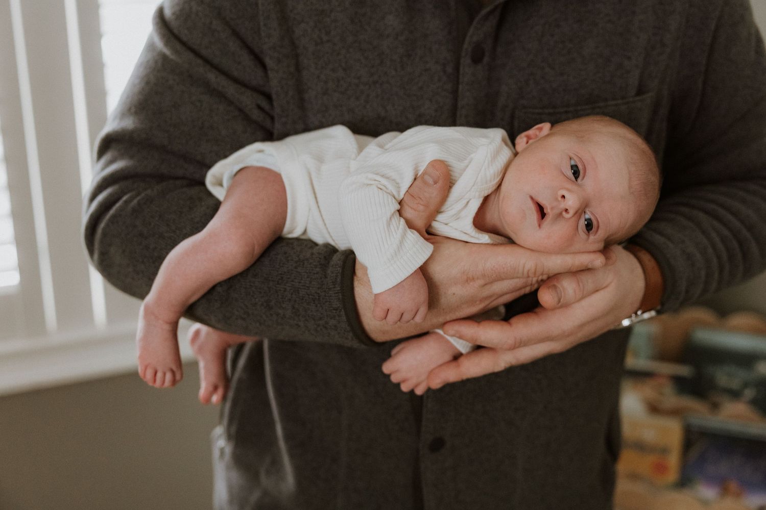 A series of tender moments between parent and baby shown in four connected photos against a neutral background.