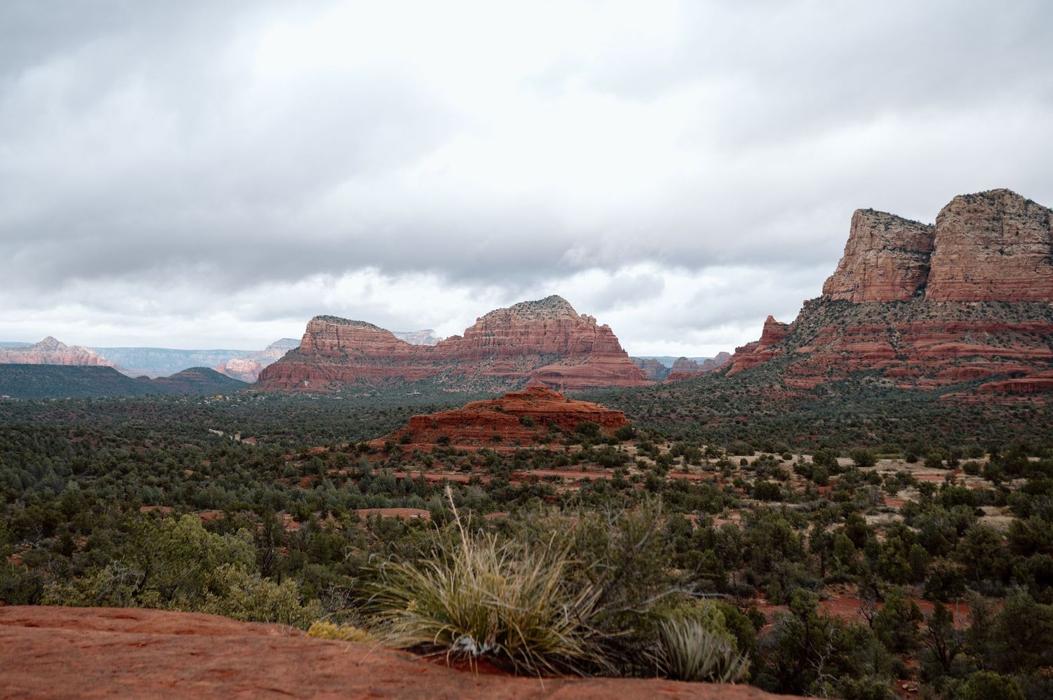 Panoramic view of red rock formations and desert landscape in Sedona Valley.