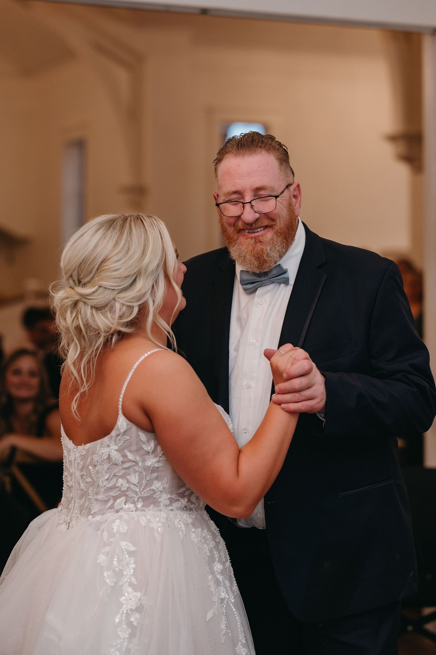 Romantic dance moment captured during wedding reception on hardwood floor.