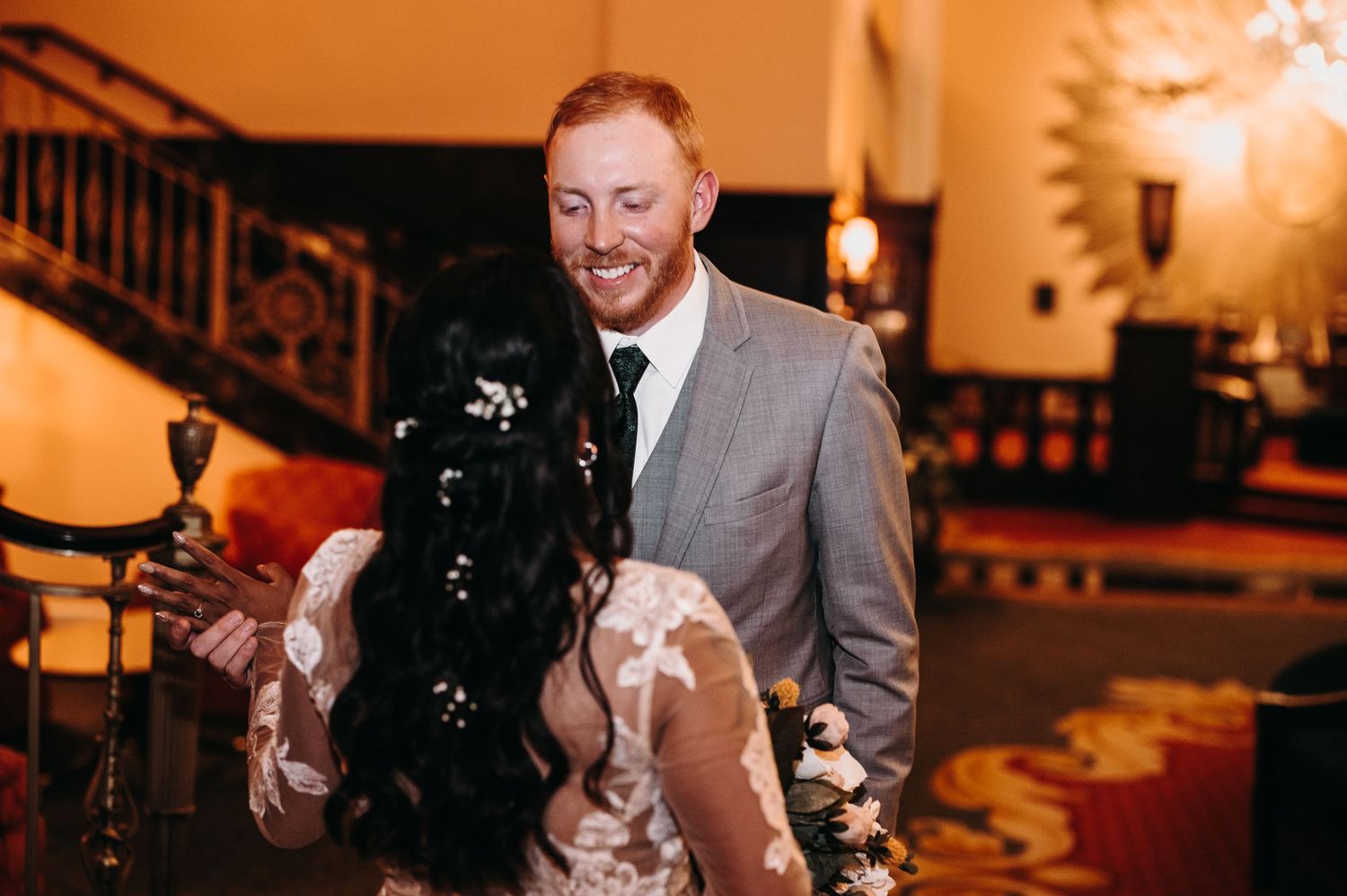 Wedding celebration moment in an elegant venue with ornate decor and warm lighting.