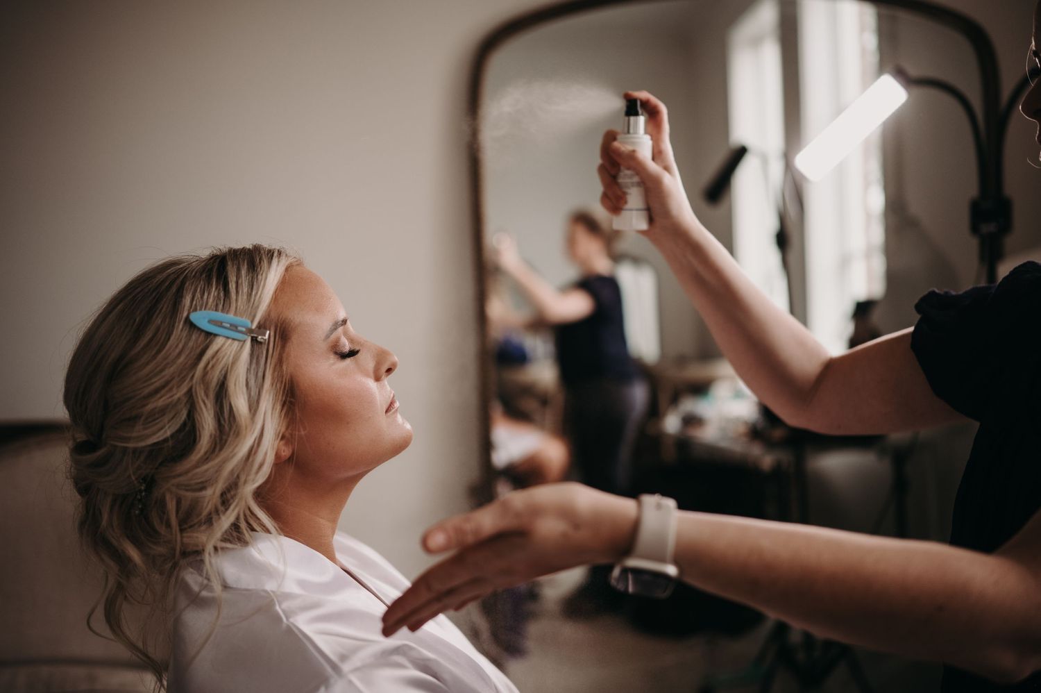 Getting ready scene with hair and makeup being applied before the wedding ceremony.