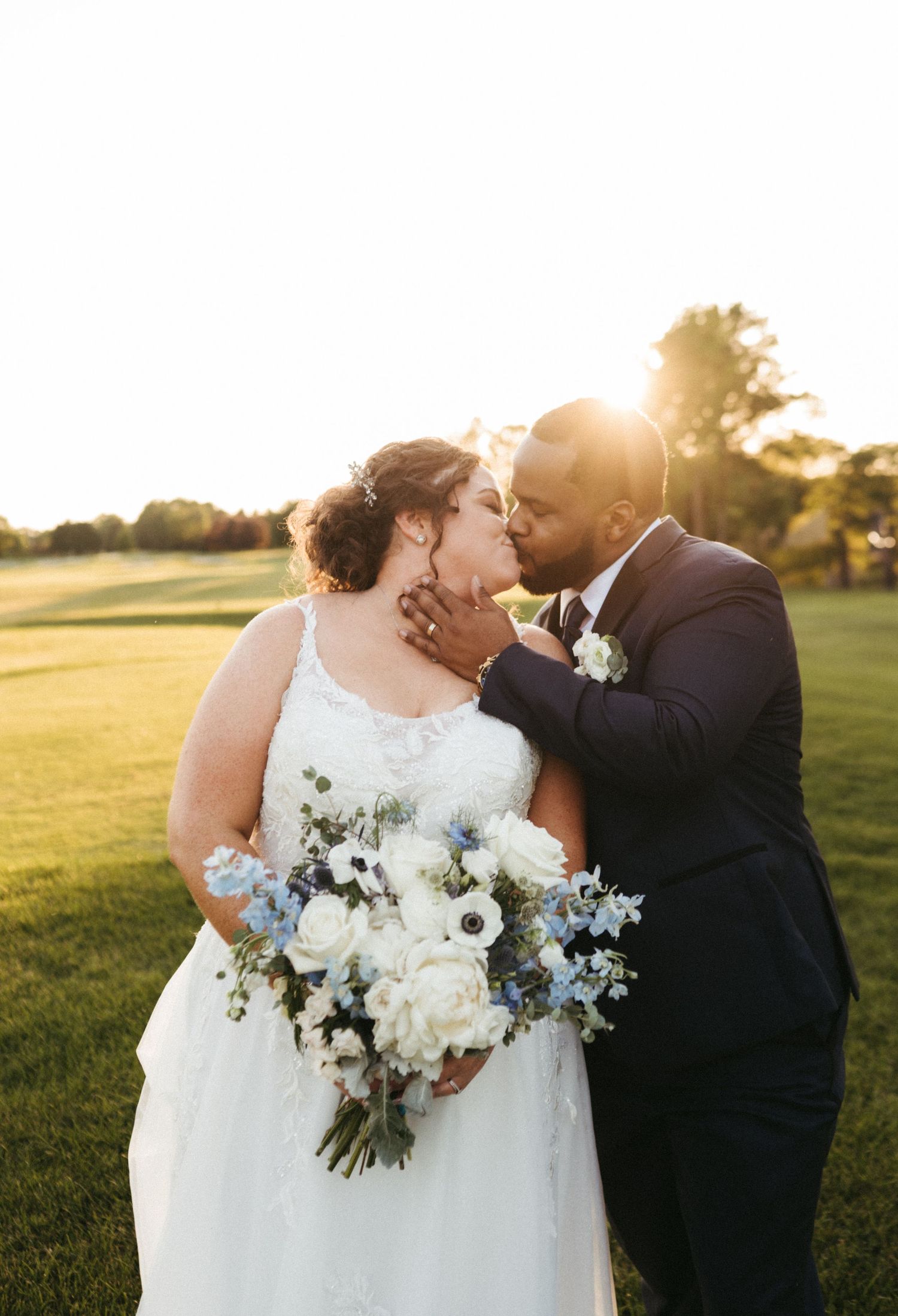 Intimate wedding couple moment at sunset with white and blue floral bouquet.