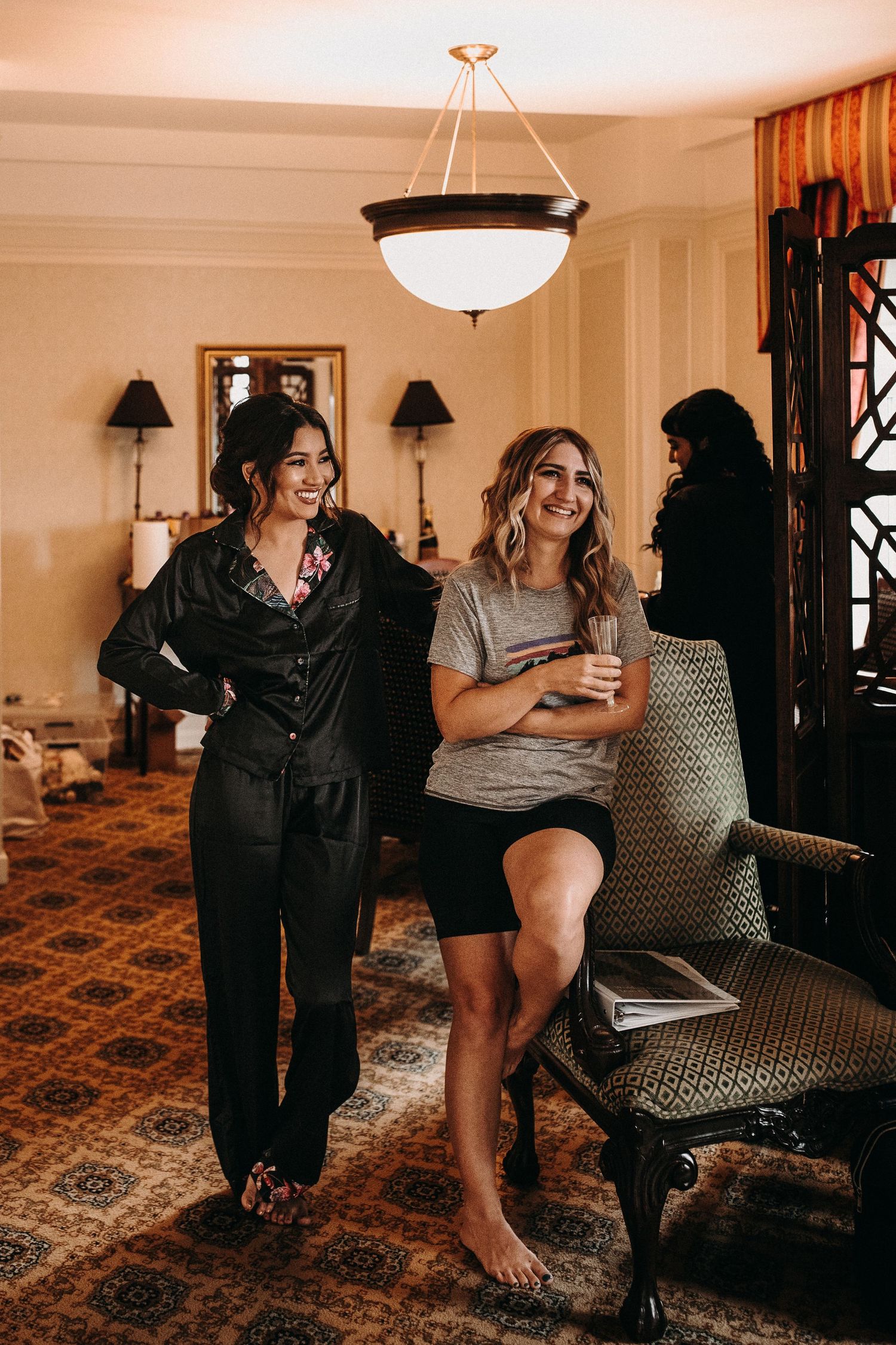 Friends enjoying a casual moment together in a cozy room with vintage furniture and warm lighting.