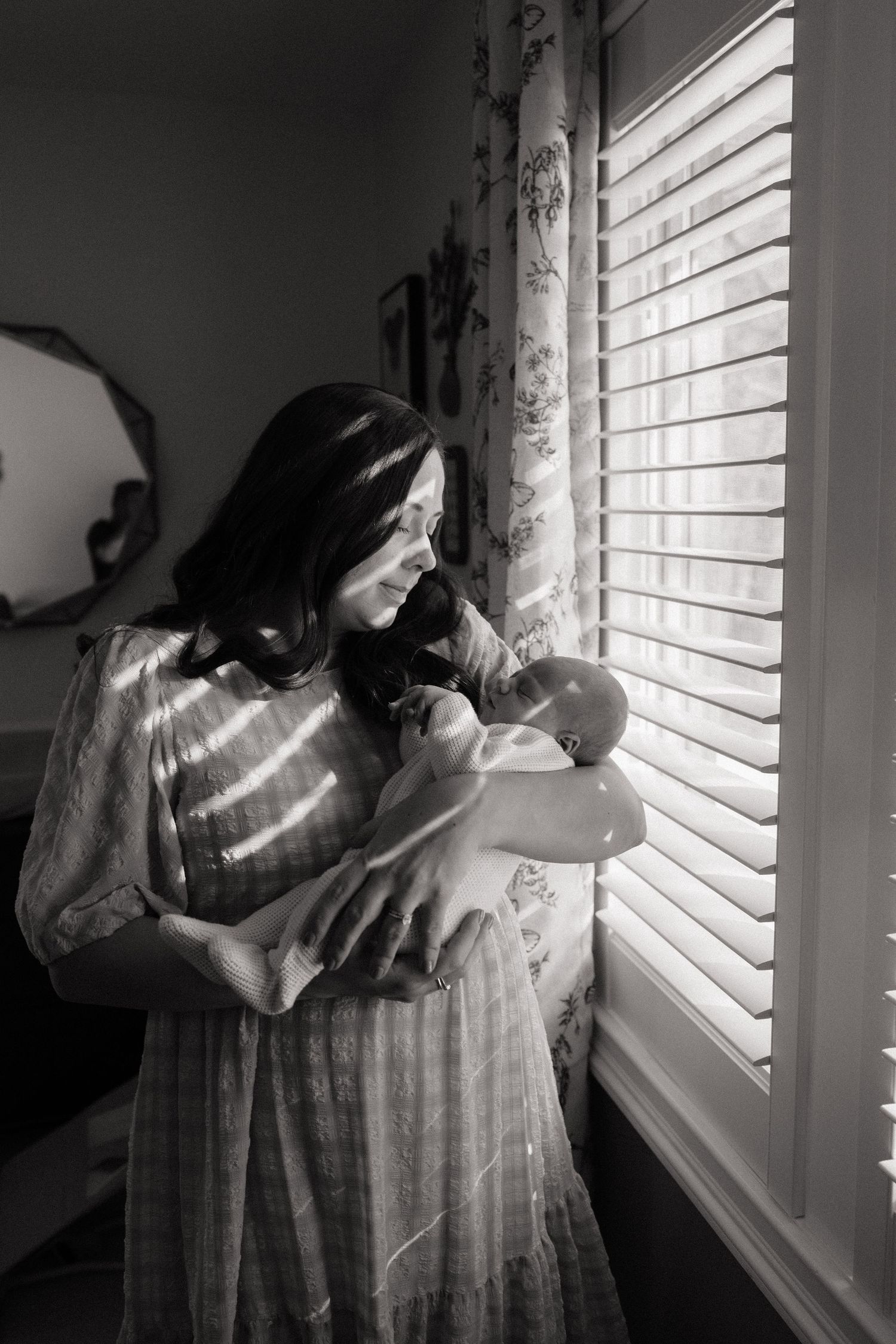 Silhouetted figures by window with sunlight streaming through blinds.