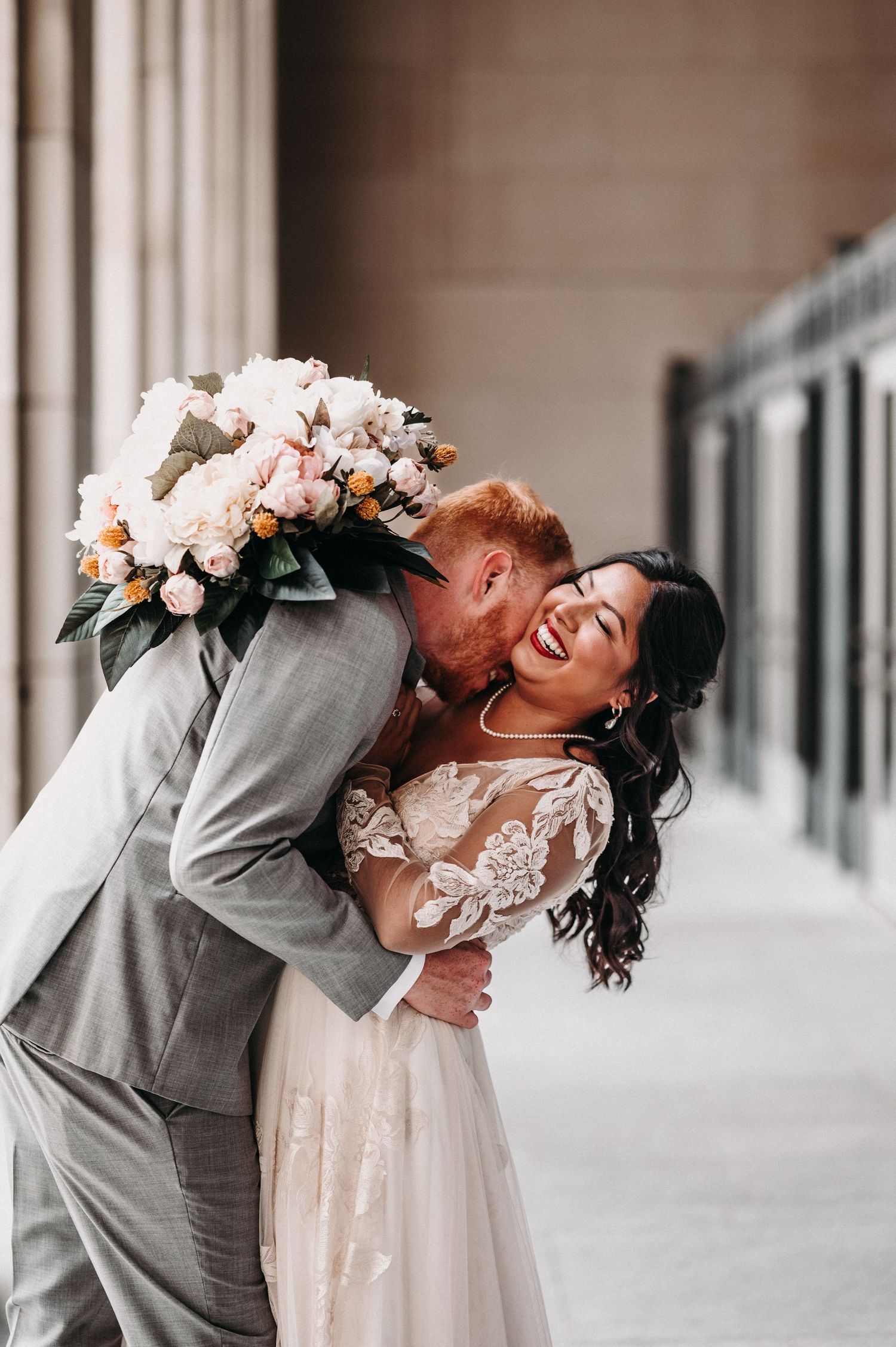 A candid wedding photo showing pure joy and laughter between newlyweds in an elegant setting.
