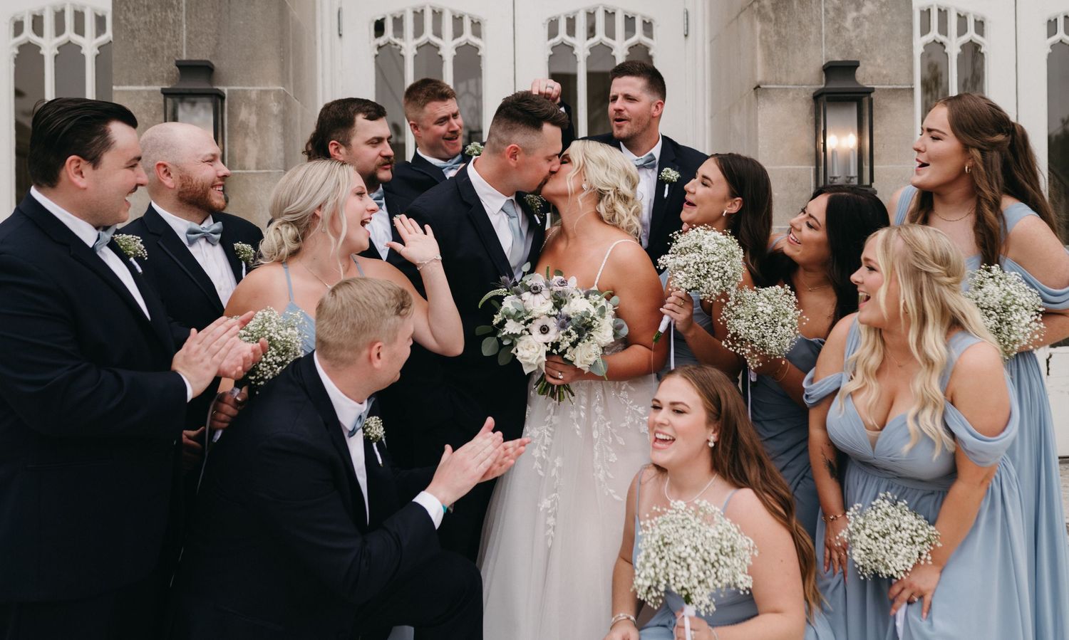 Candid moment of wedding party laughing together during formal photos.