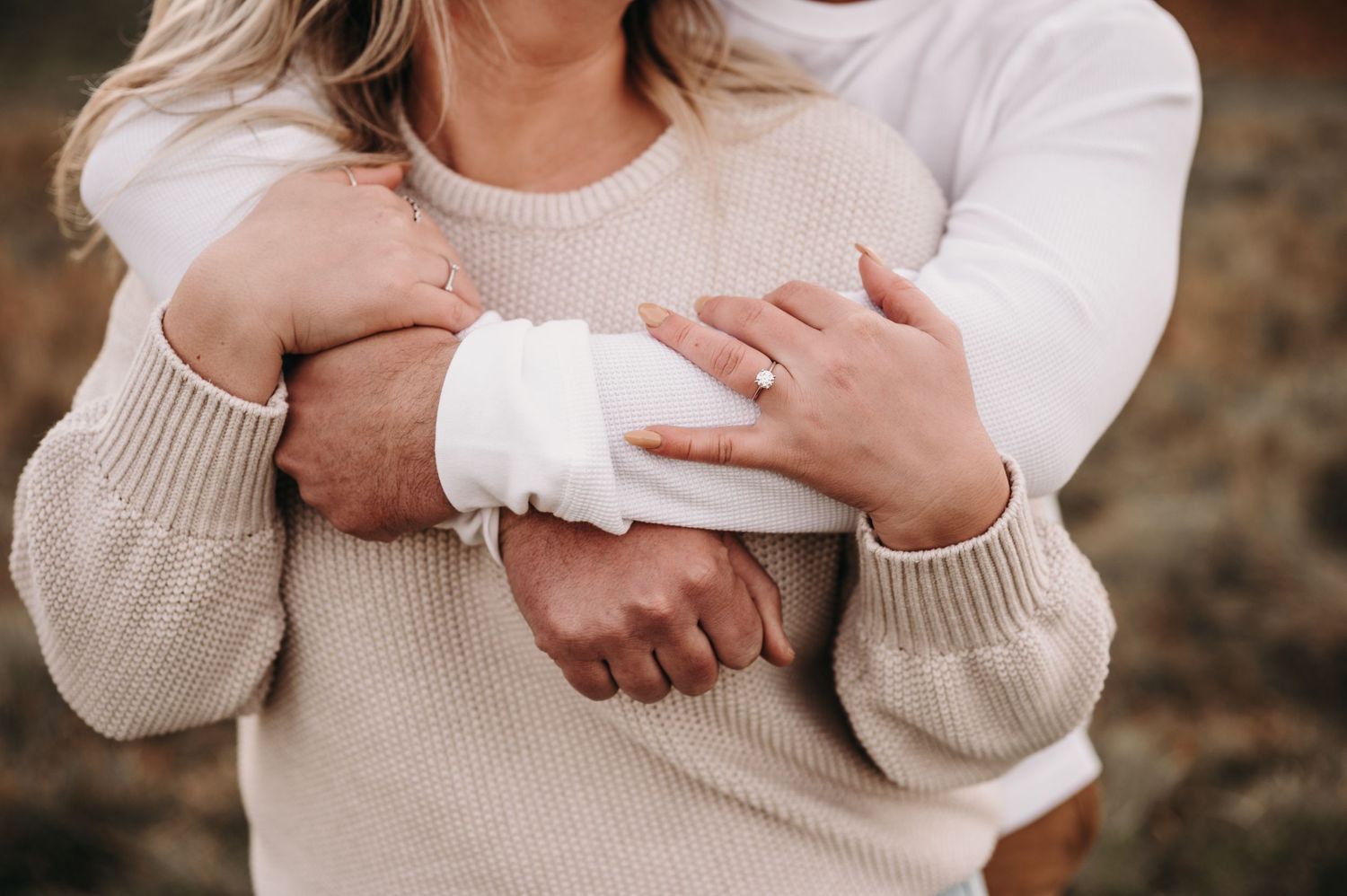 Close-up of couple embracing in cozy sweaters during autumn photoshoot.
