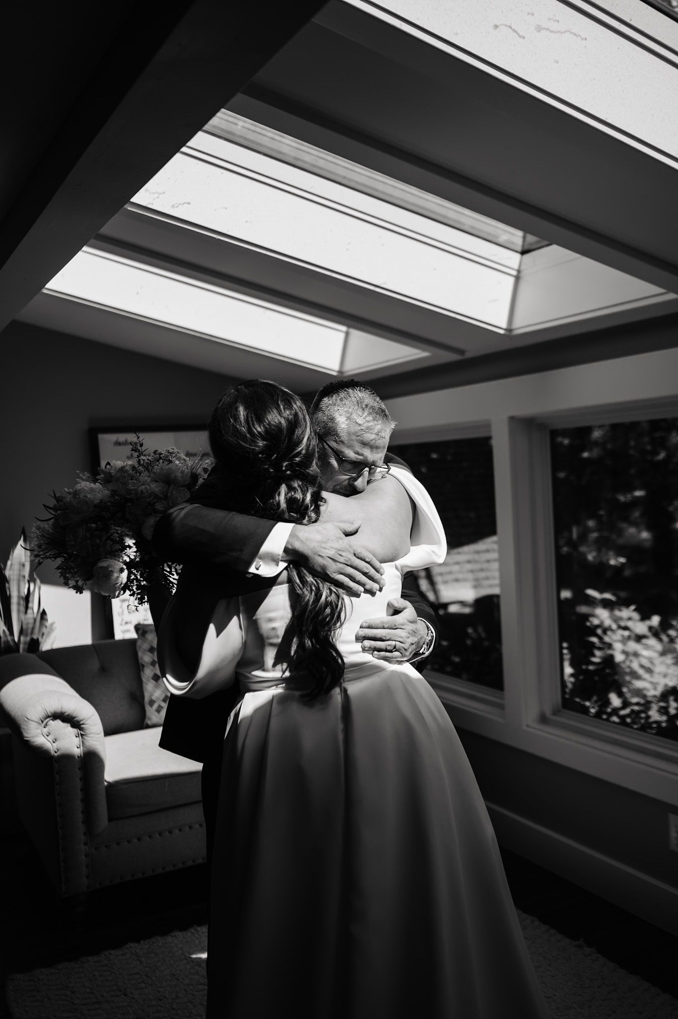 Intimate black and white moment captured under skylight windows.