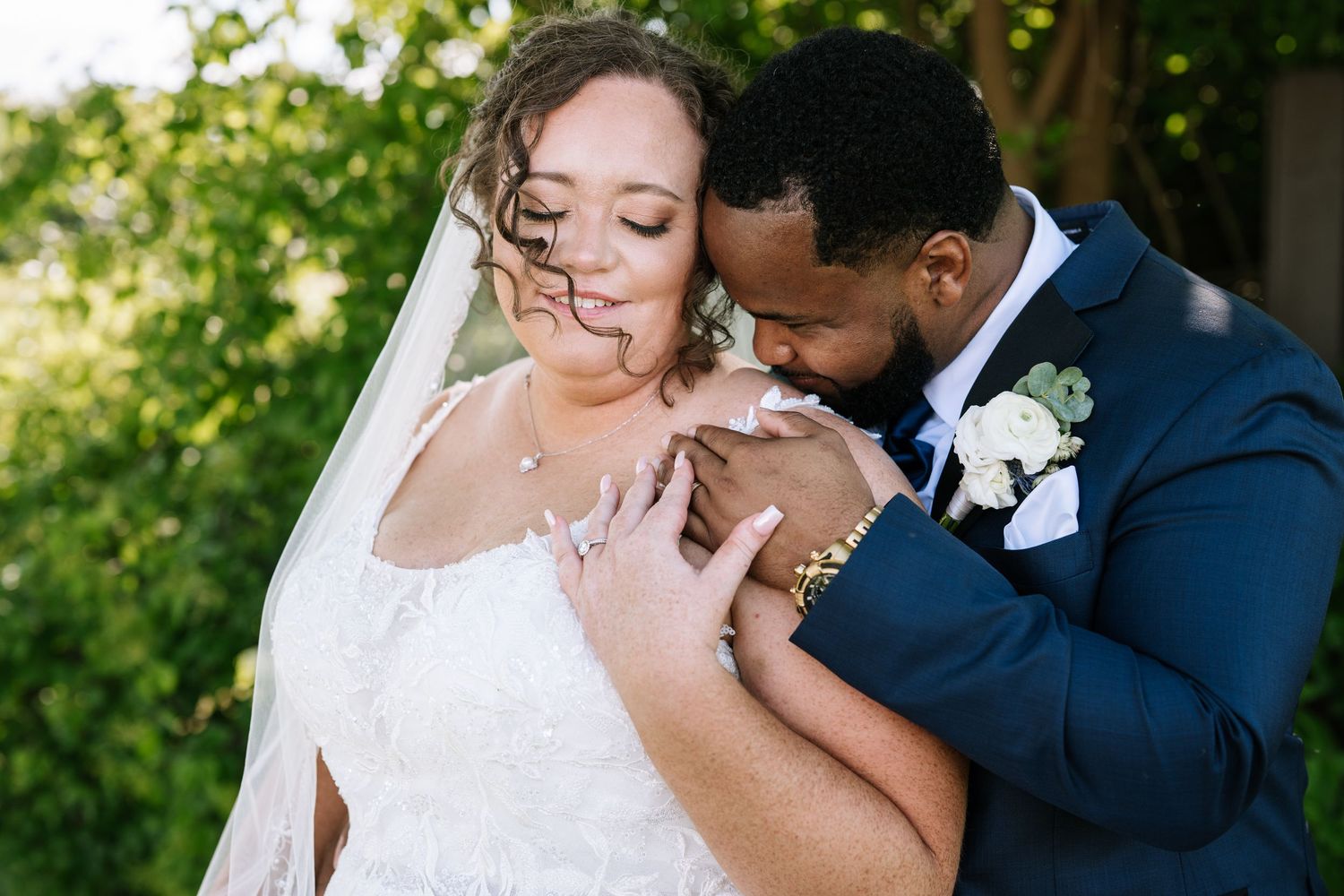 Romantic wedding portraits captured in natural outdoor setting with greenery.