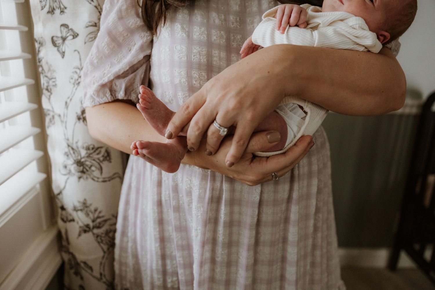 Close-up shots of gentle hands holding and caring for a small infant.