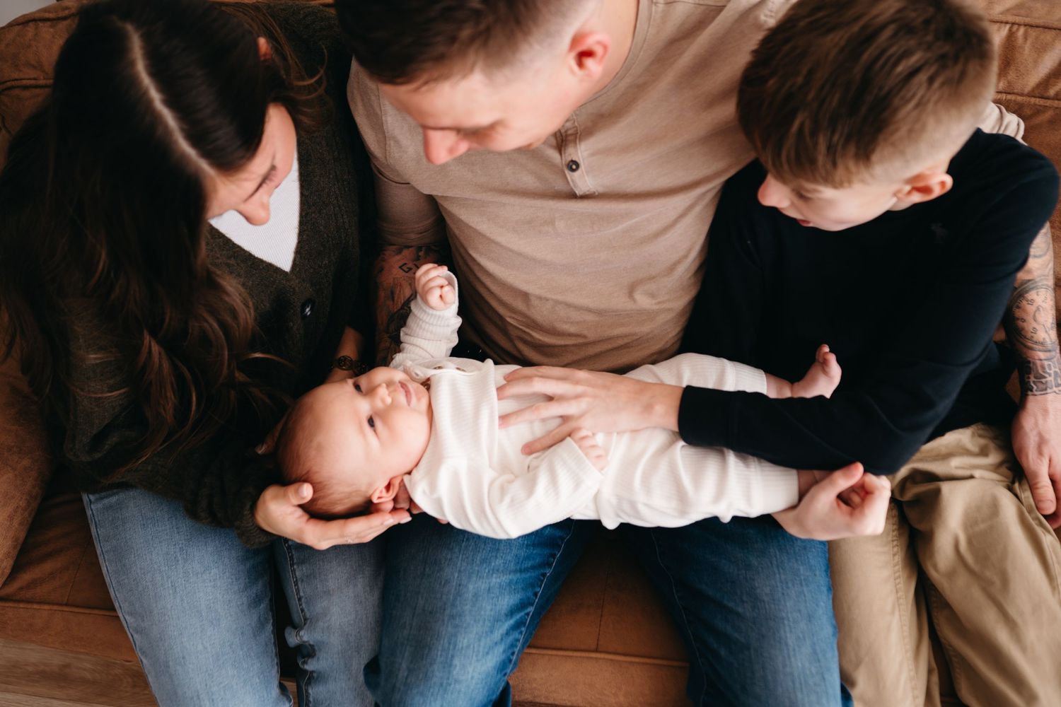 Candid family moment of parents and children lounging together in coordinating outfits.