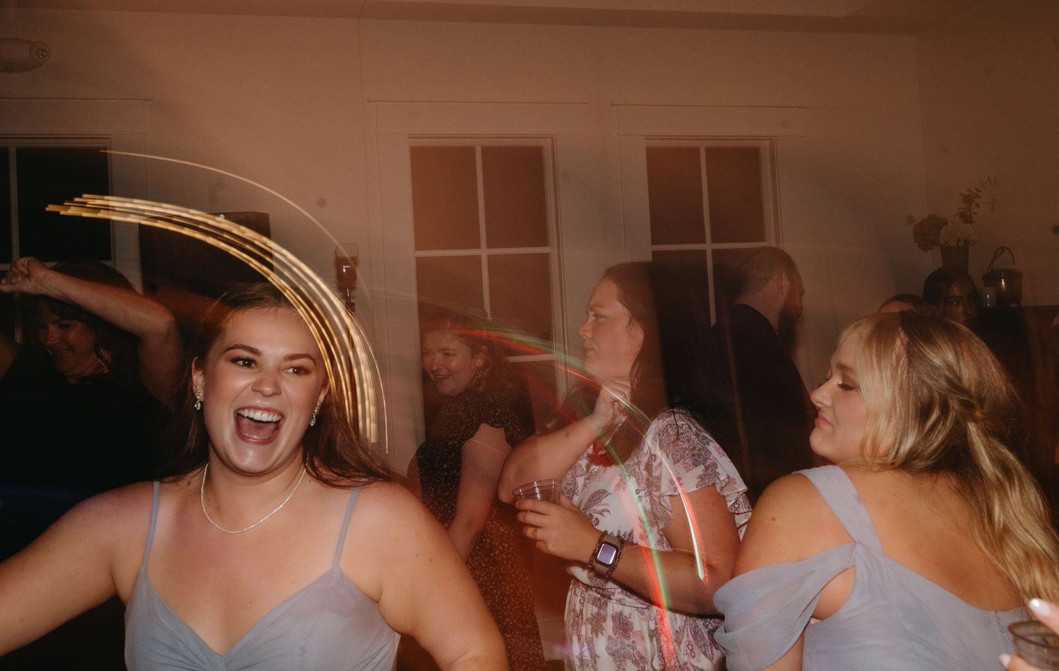 Guests dancing and celebrating at a lively wedding reception party.