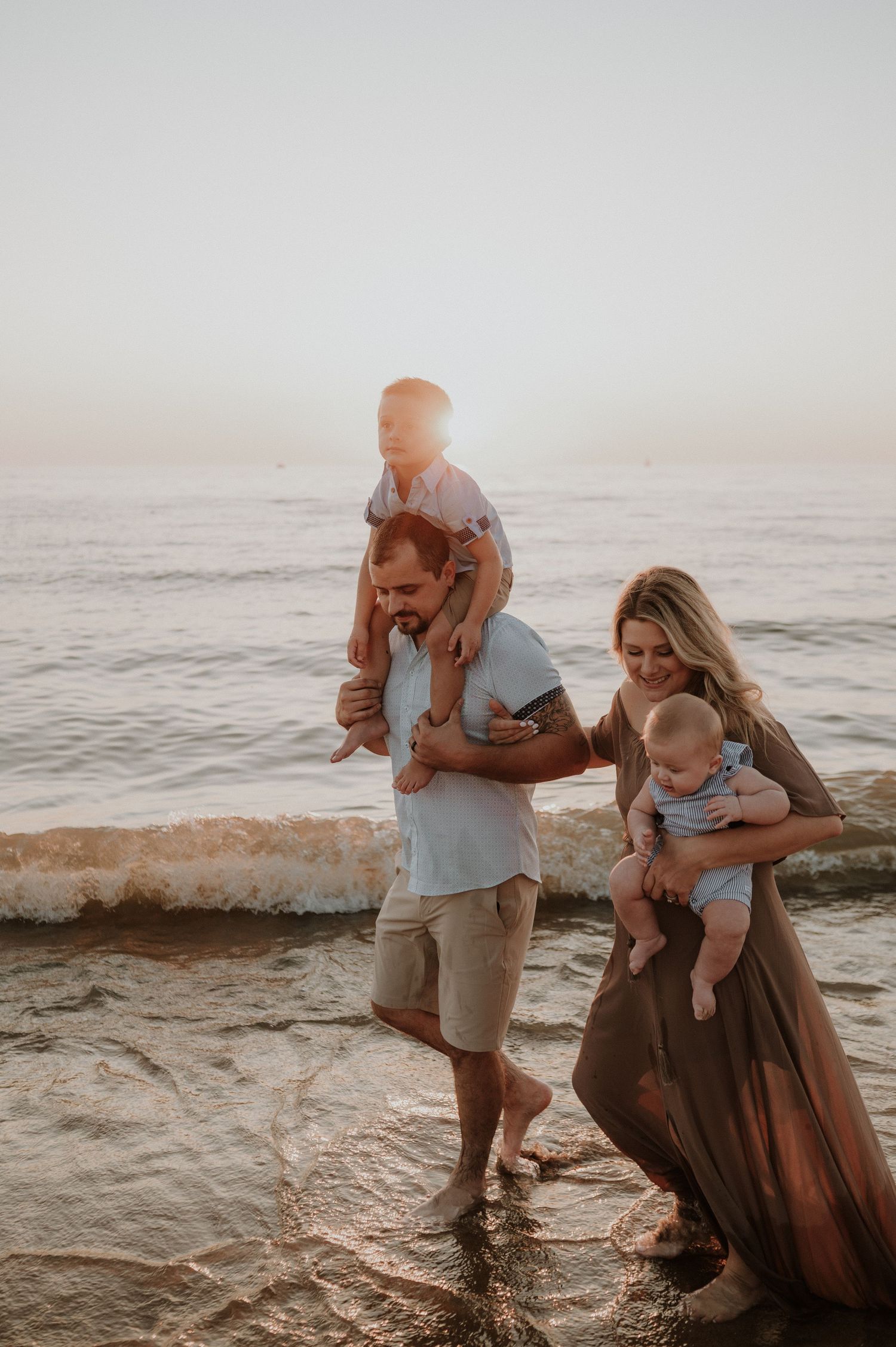 Family sharing joyful moments together on a beach at sunset.