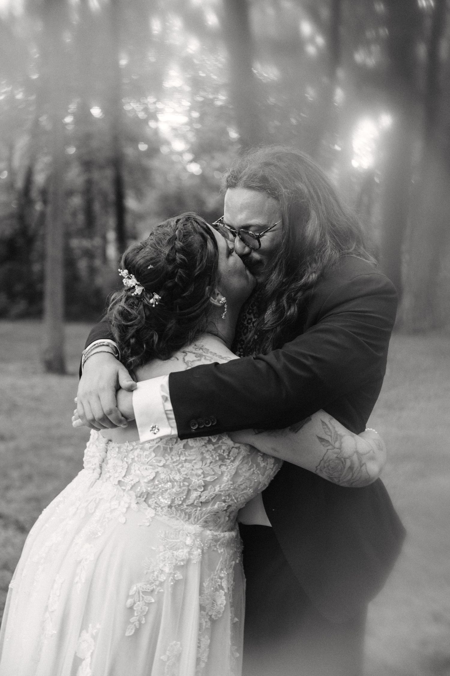 A tender black and white romantic moment captured between a couple in formal attire.