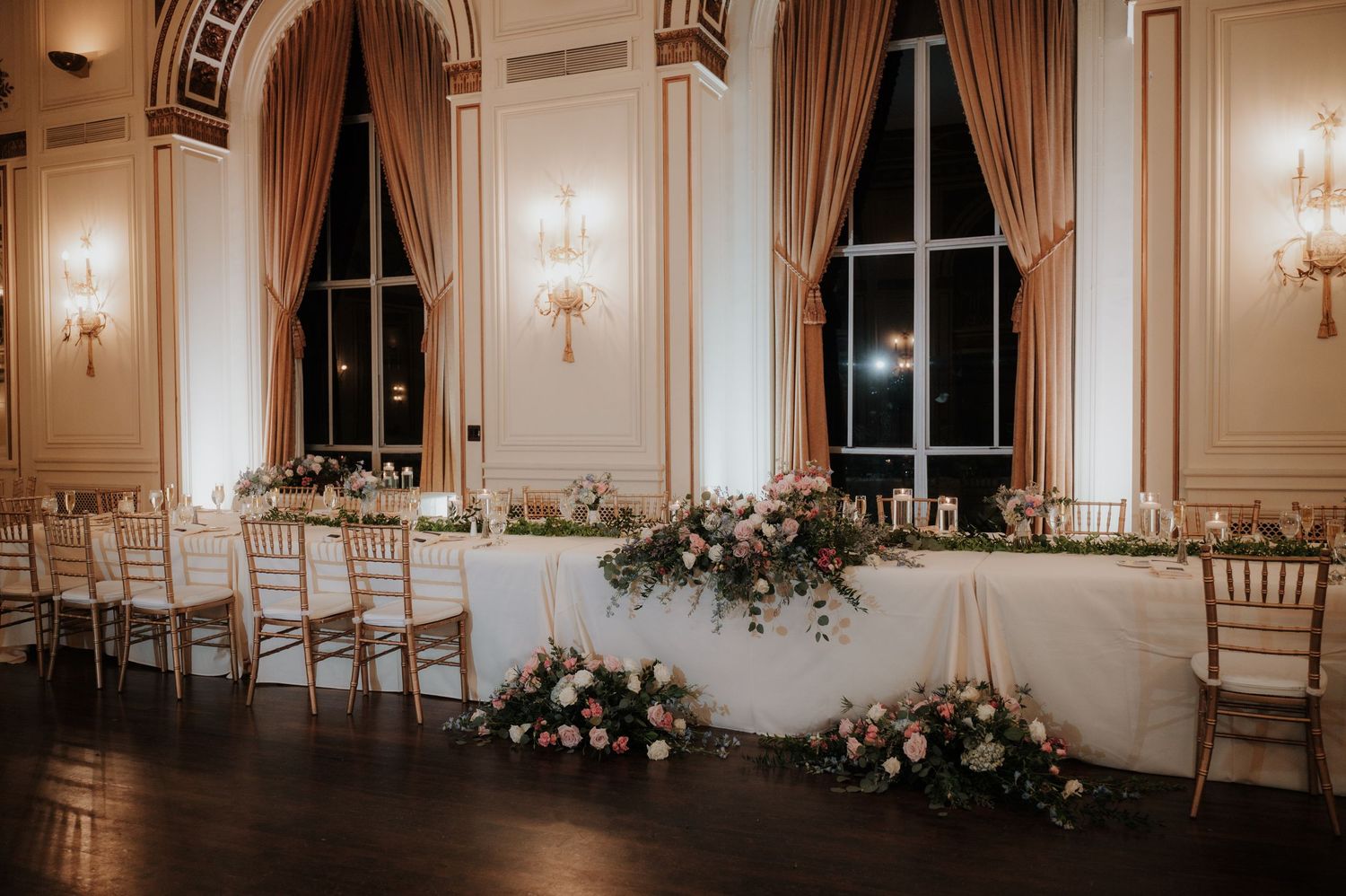 Elegant ballroom venue with warm lighting and classic white decor for wedding reception.