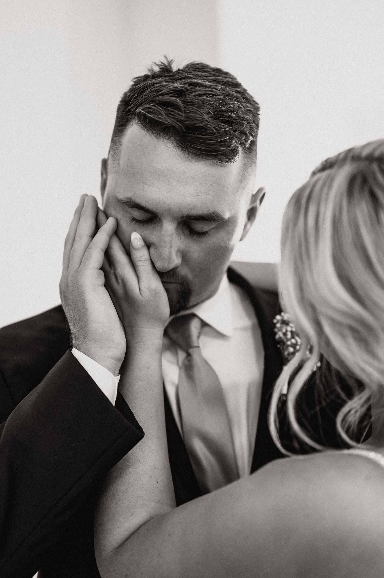 Black and white emotional moment between couple during wedding ceremony.