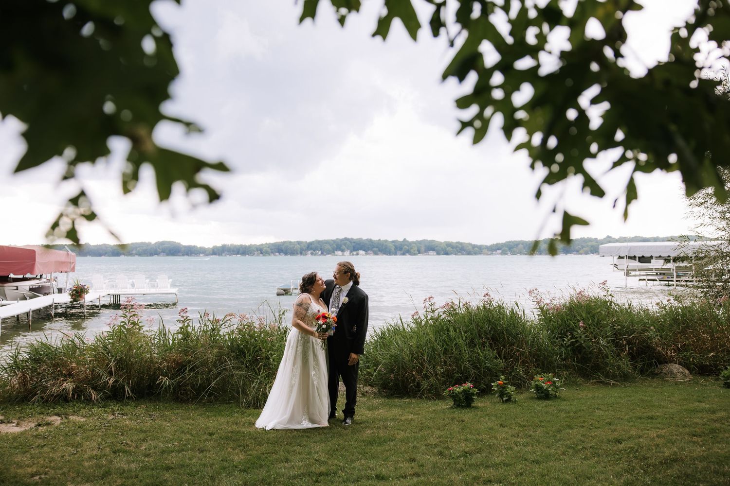 Scenic waterfront wedding ceremony setup with trees and ocean view in the background.