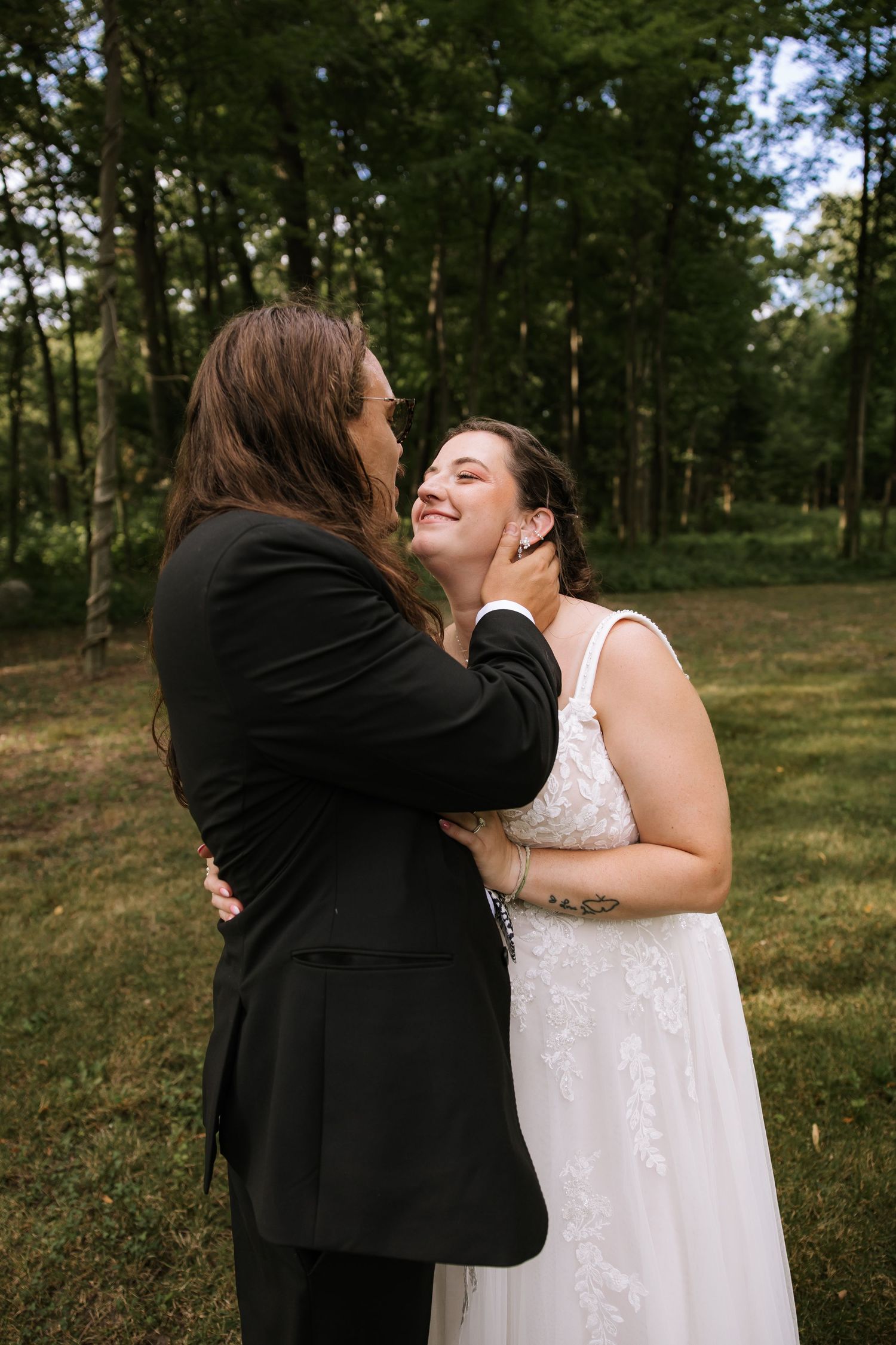 Emotional moment between two people embracing outdoors during a wedding celebration.
